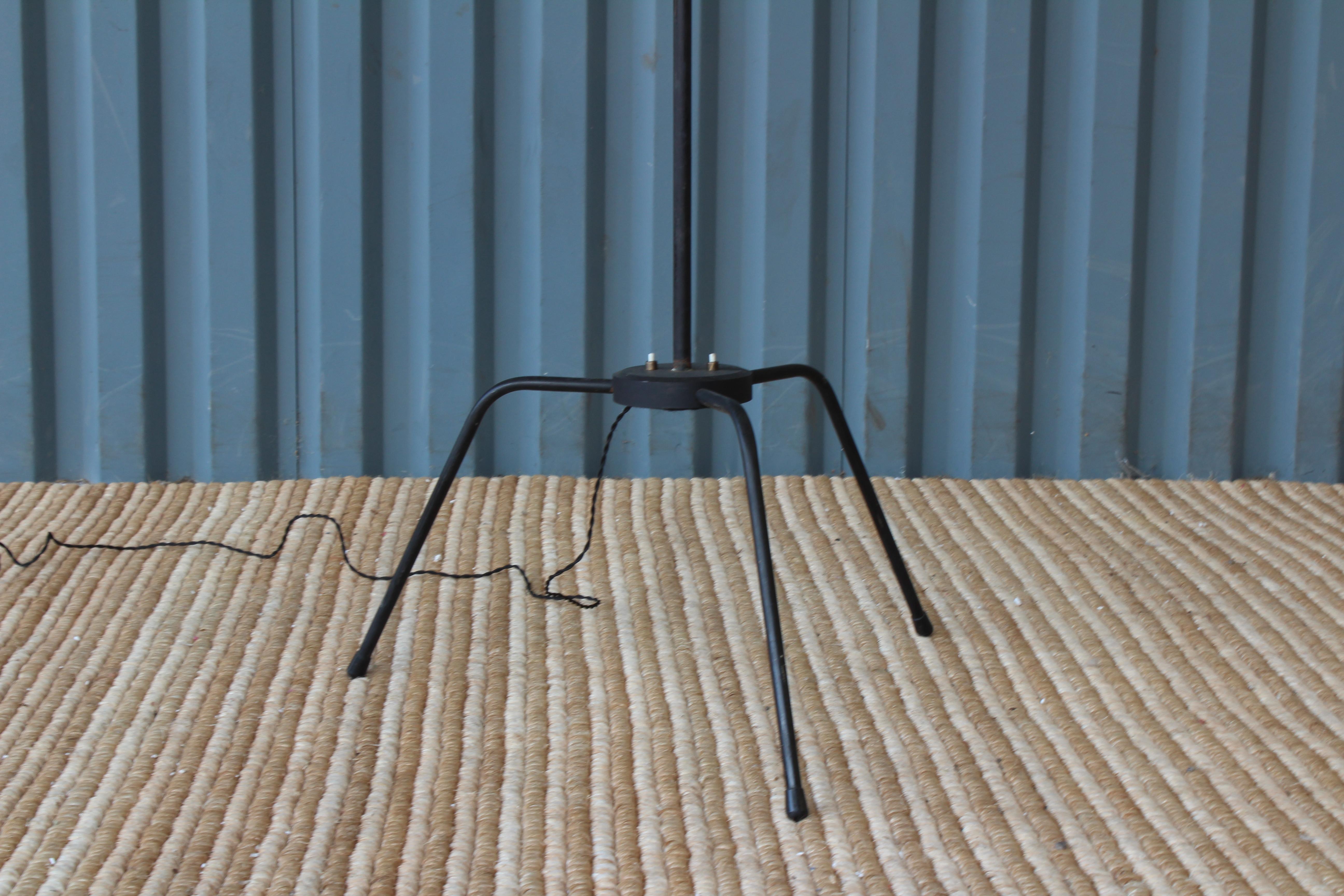 Unique French 1950s iron floor lamp. Pair available. They both have been rewired and feature custom fitted linen shades with black edged details.