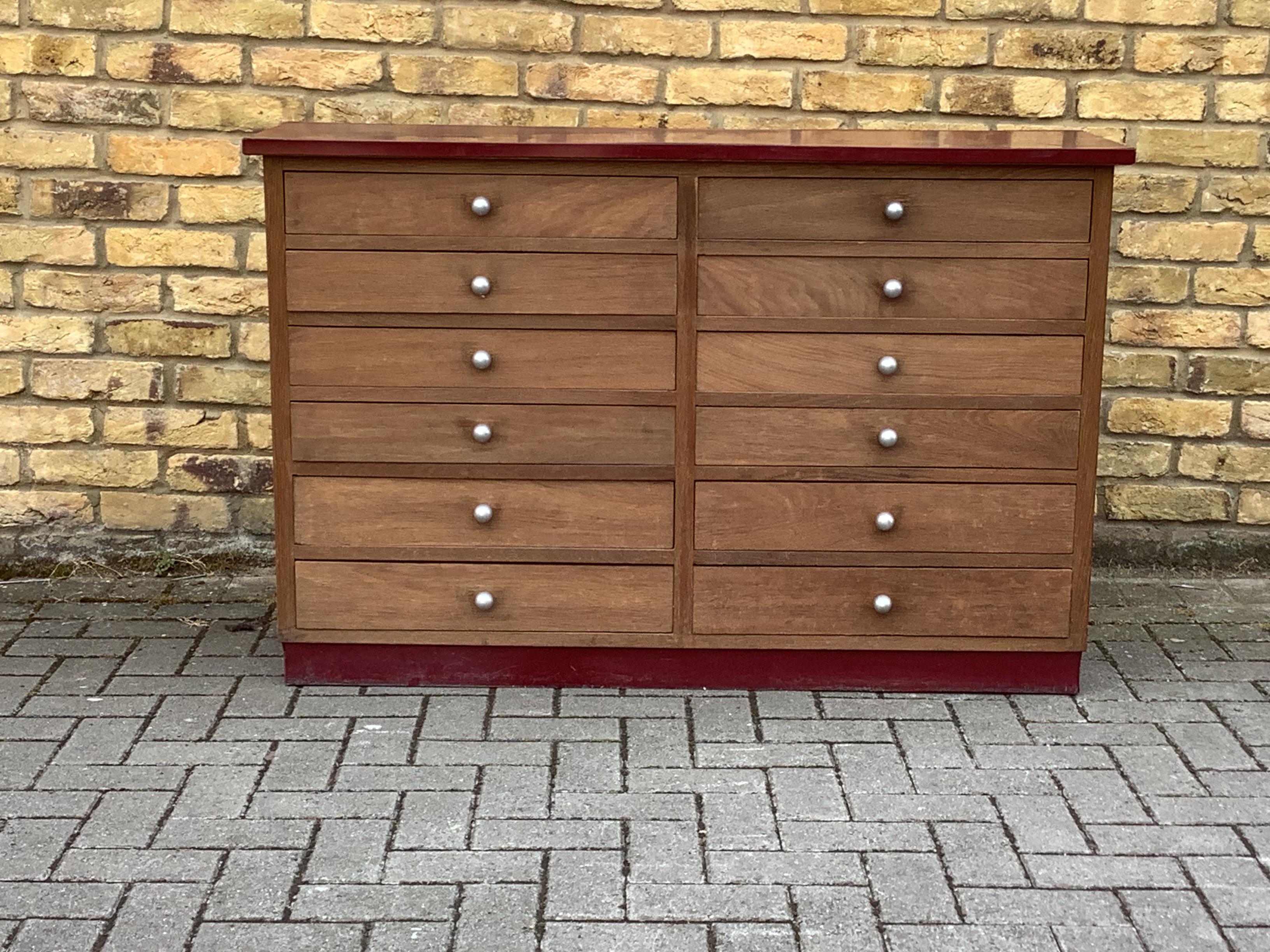 Compact set of 12 storage draws in oak with a Formica top and bottom 
Strip.Lovely set of 12 steel round handles.Flexible storage cabinet.