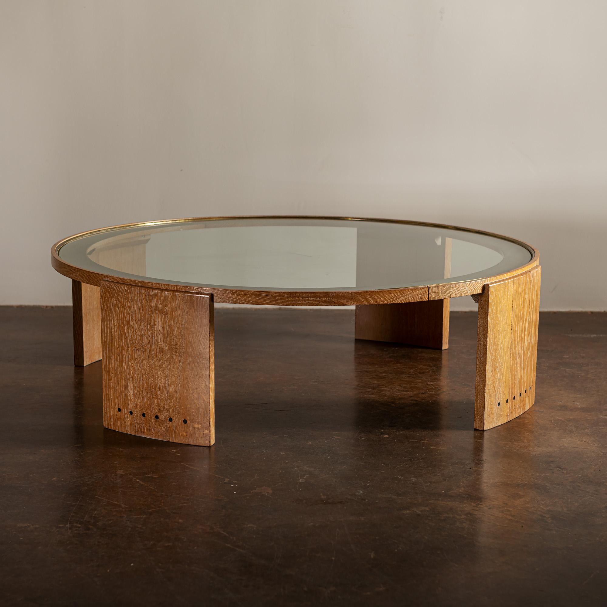 Elegant oak and glass coffee table from France with lovely details. Beautiful etching along glass edge, with brass surrounding glass top. Nice contrasting wood details along bottom of legs, circa 1950s.