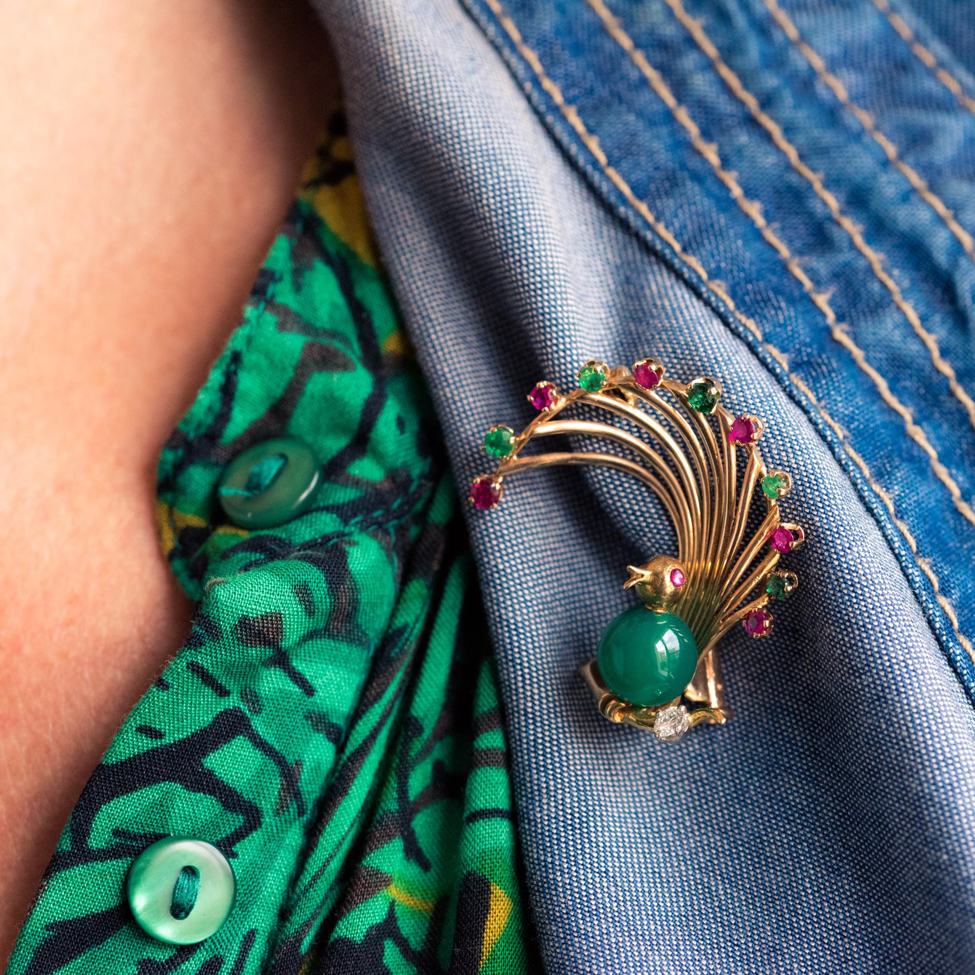 Brooch in 18 karat yellow gold, eagle's head hallmark.
Lovely retro brooch, it represents a bird of paradise, the feathers being set with alternating rubies and emeralds, the belly a chrysoprase pearl, the eye, a cabochon ruby. The bird is placed on