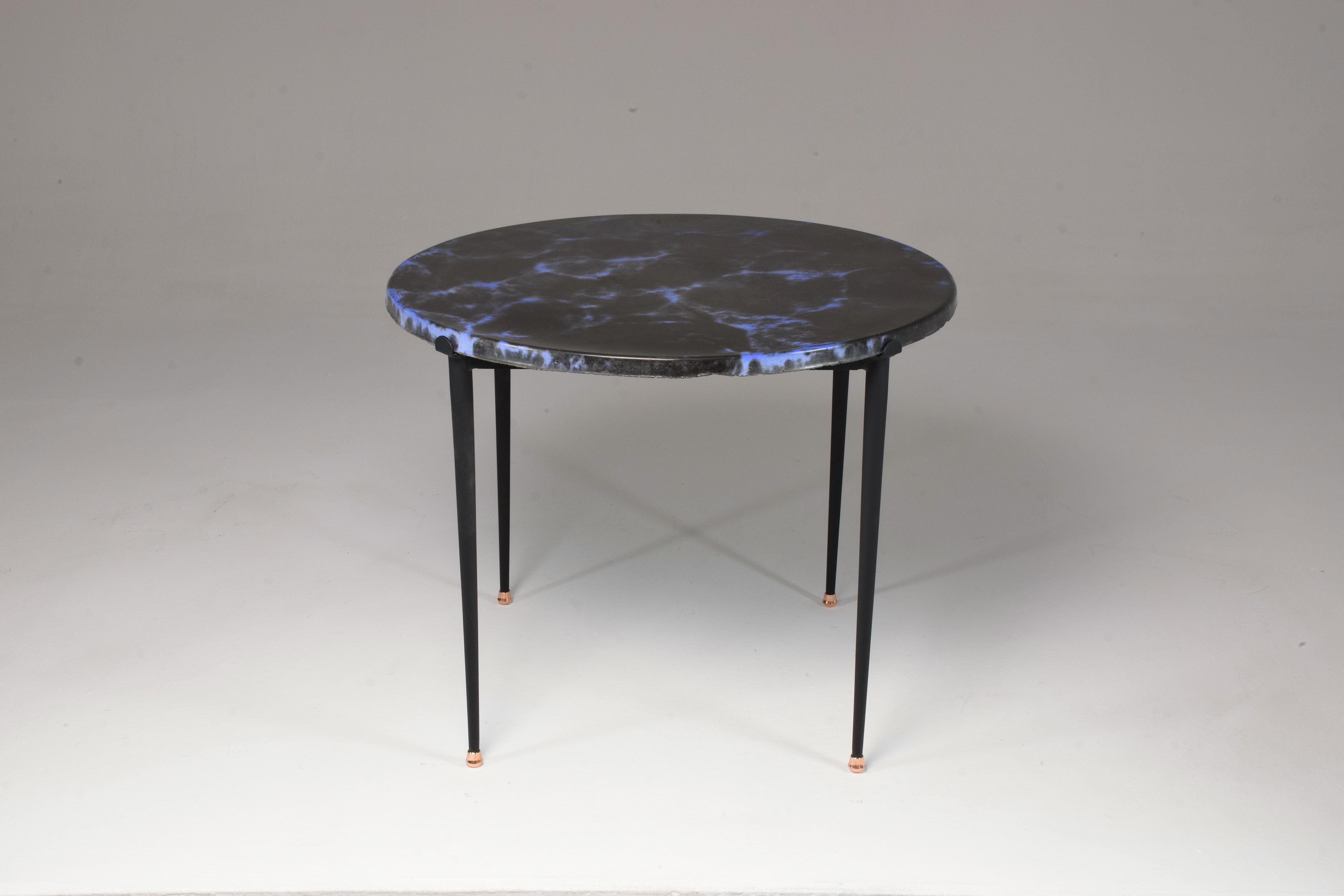 A super cool 20th-century French vintage circular side coffee table with an enameled lava stone blue and black patterned handcrafted tabletop and a chic black steel structure with copper endings. 
In the style of les 2 Potiers. 
France, Circa