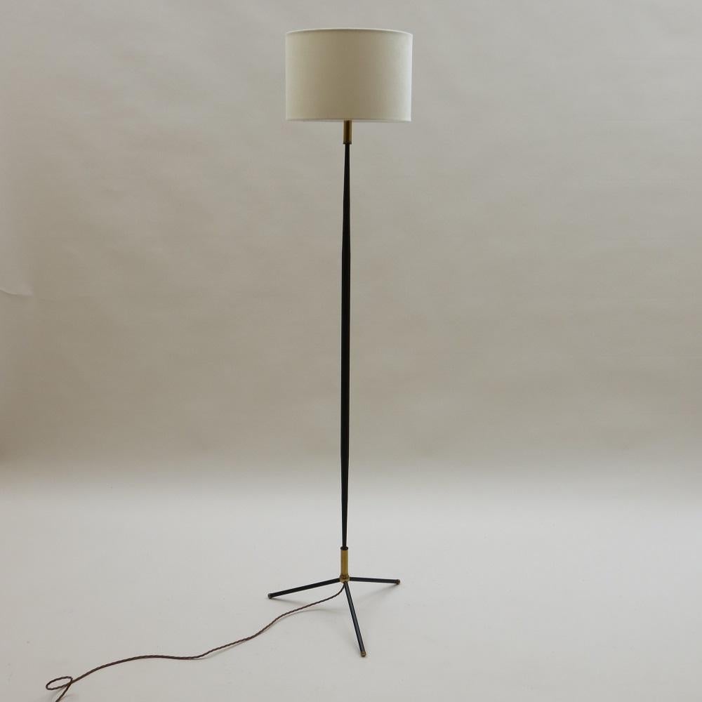 1950s steel and brass floor lamp with new replacement shade in ivory velvet. Metal base with brass detail on each foot and to the top and bottom of the lamp. The lamp has been newly rewired and is in good working order. 
A very elegant good quality