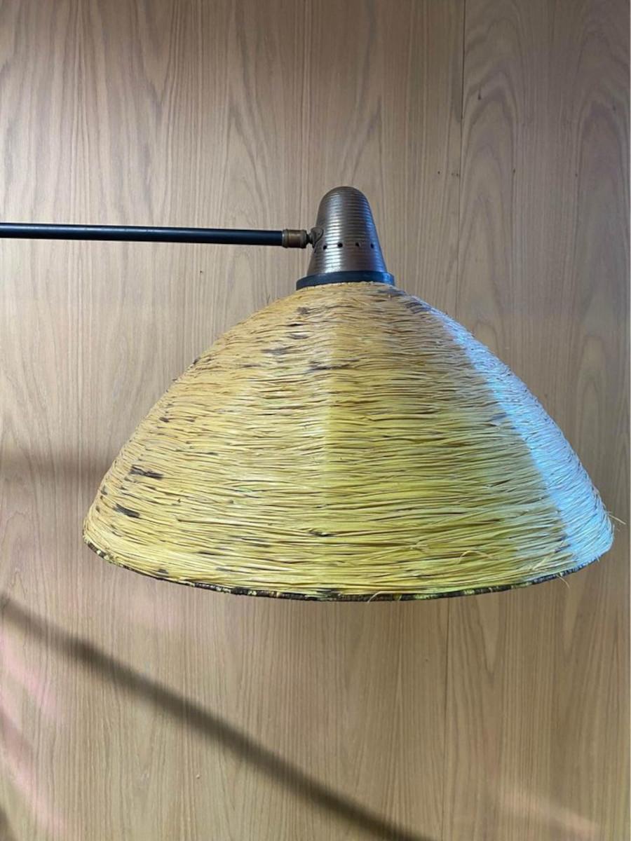 We are delighted to offer this exceptionally rare lamp by Maison Arlus, crafted in the 1950s. This stunning piece showcases a beautiful rattan shade and handle, complemented by perforated metal details and solid brass accents. Fully adjustable in