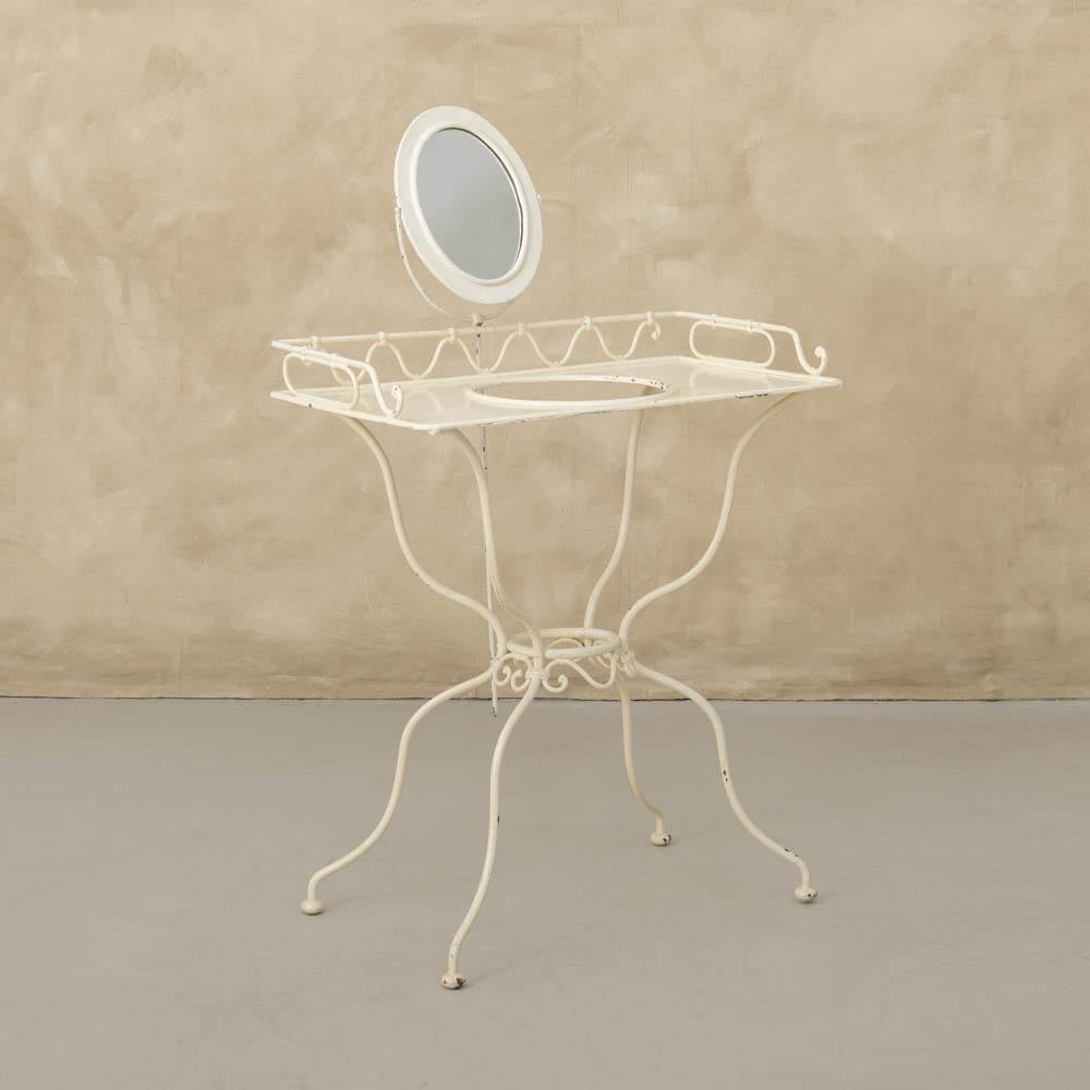Unique iron vanity from France, 1950's. Painted white iron vanity with removable mirror and table surface on 4 curvy legs with wavy detail. Circular cut out on surface for sink basin. 


