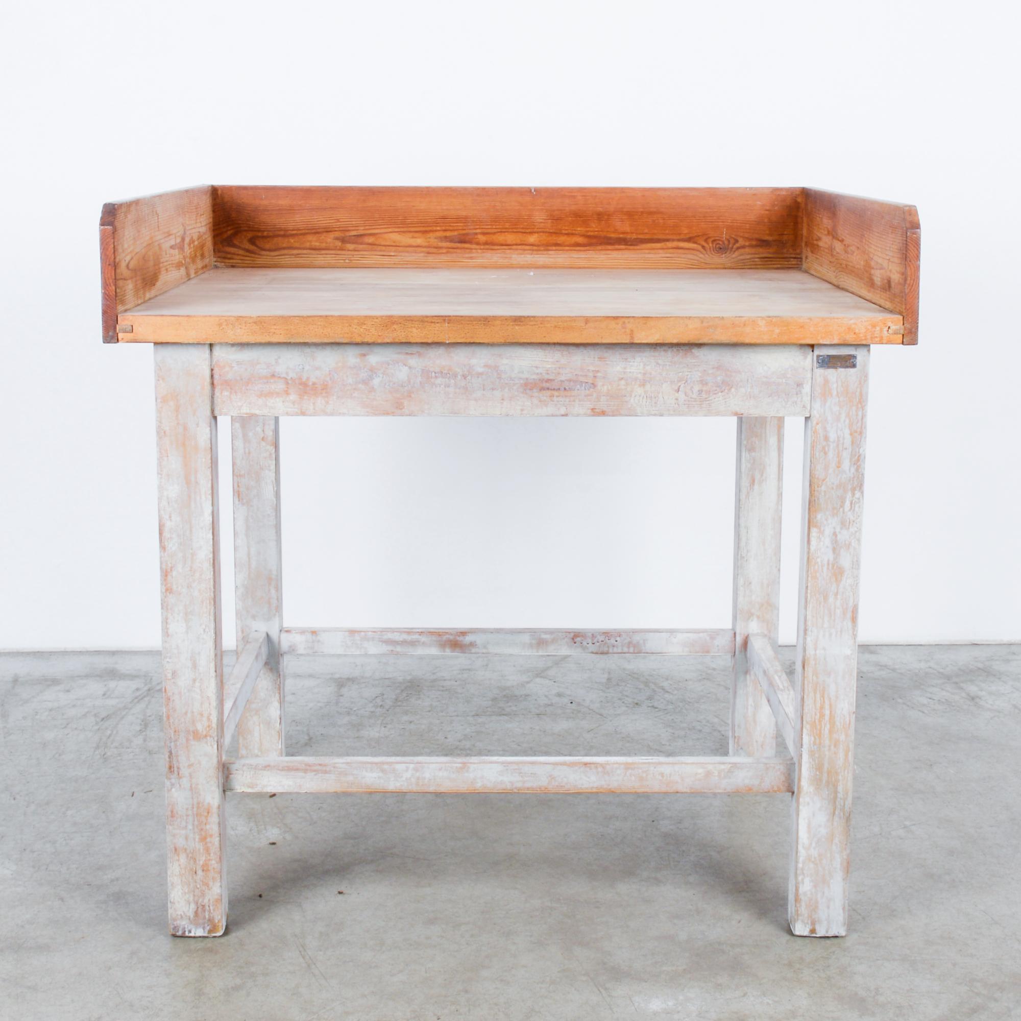 This wooden baker’s table was made in France, circa 1950. The polished wood panels that line the sides and the back keep the flour and baking ingredients on the tabletop. The sturdily constructed frame displays a milky white patina and evokes the