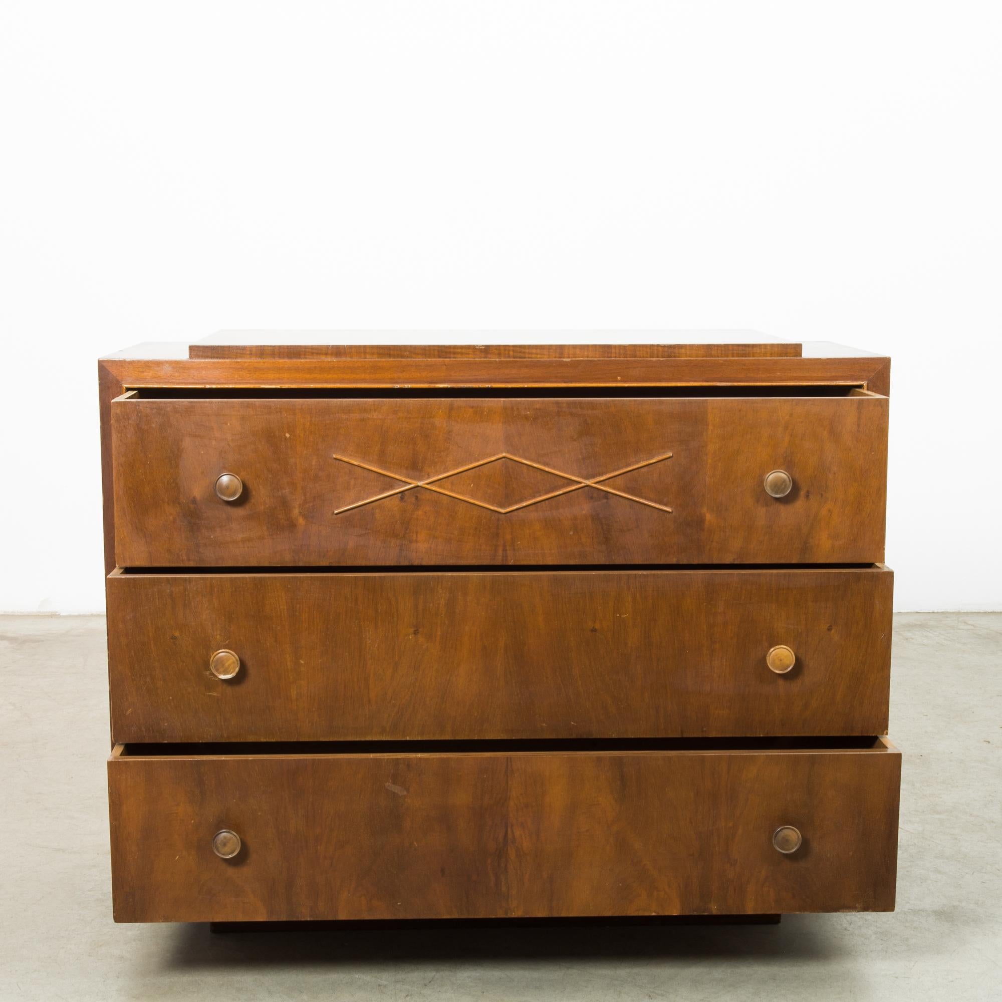 Step back into the grace of 1950s French design with this exquisite wooden chest of drawers. This piece brings the charm of a Parisian antique shop right into your bedroom or living space. The warm, honey-toned wood is rich with character,