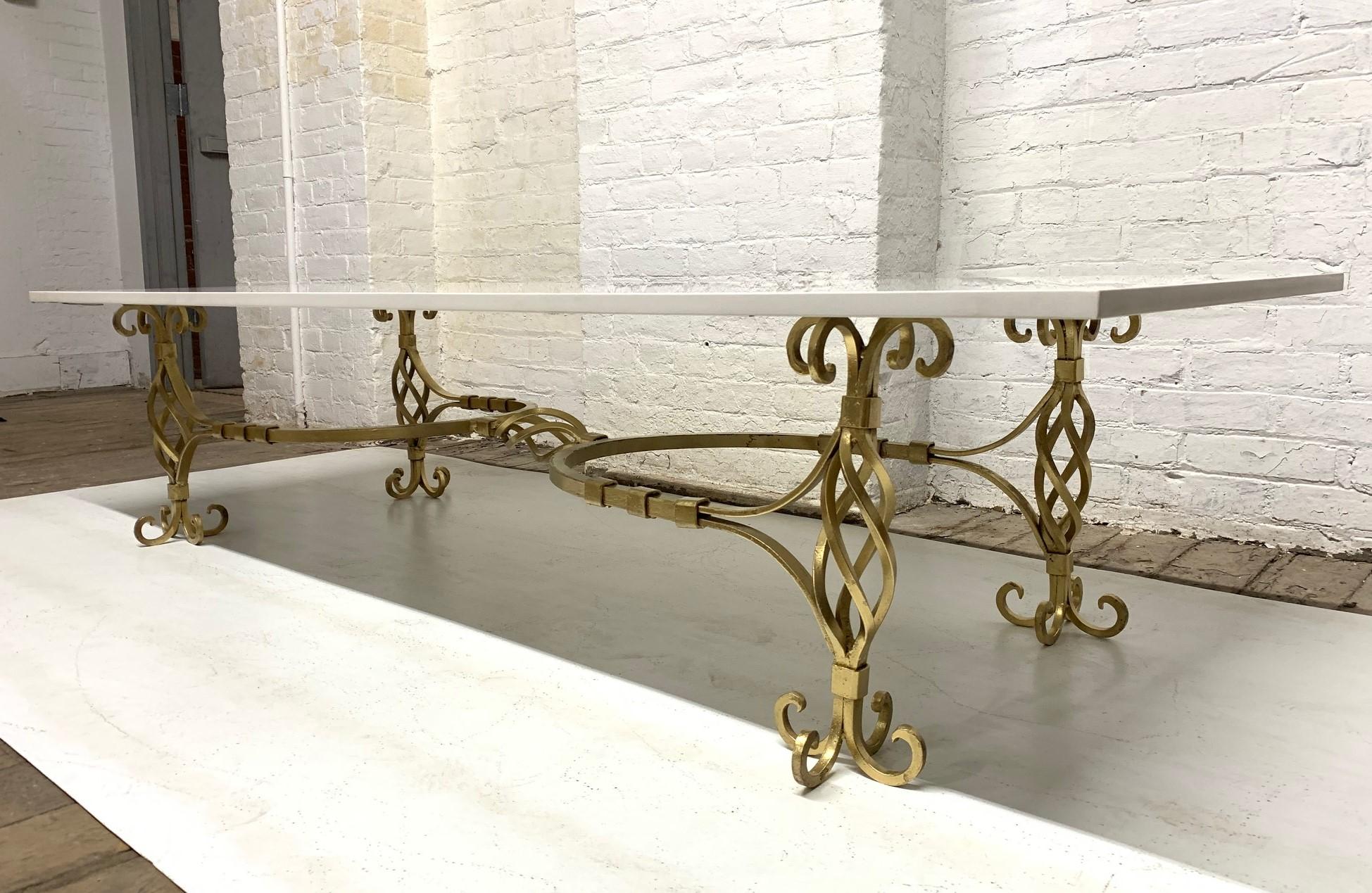 table basse française des années 1950 en fer forgé doré avec plateau en quartz.