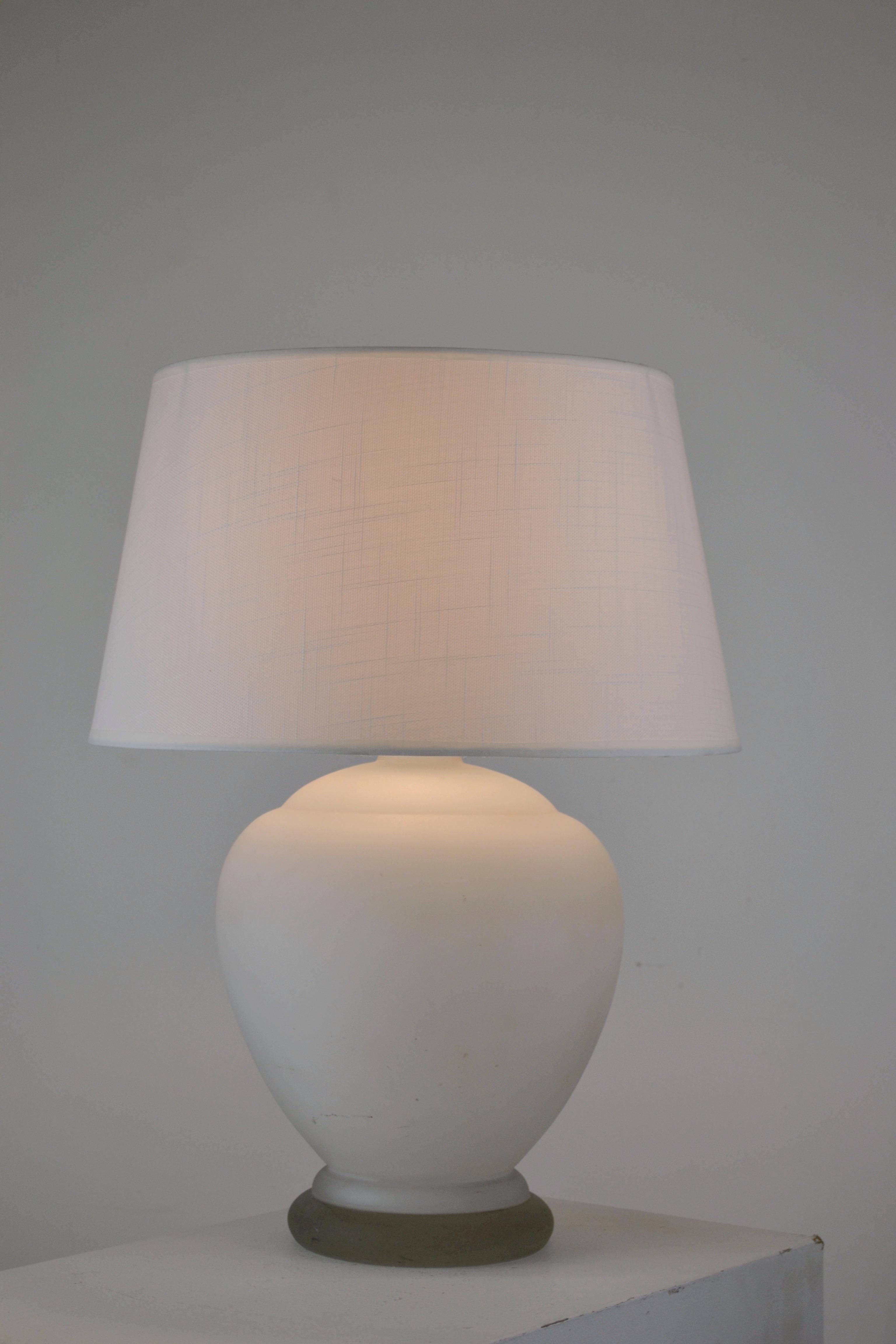 Elegante Tischleuchte aus der Mitte des Jahrhunderts mit einem sanft gerundeten Sockel aus mattweißem Milchglas, gestempelt in der Tschechoslowakei.
Vollständig neu verkabelt nach aktuellen Standards. Der neue maßgefertigte Schirm ist dem