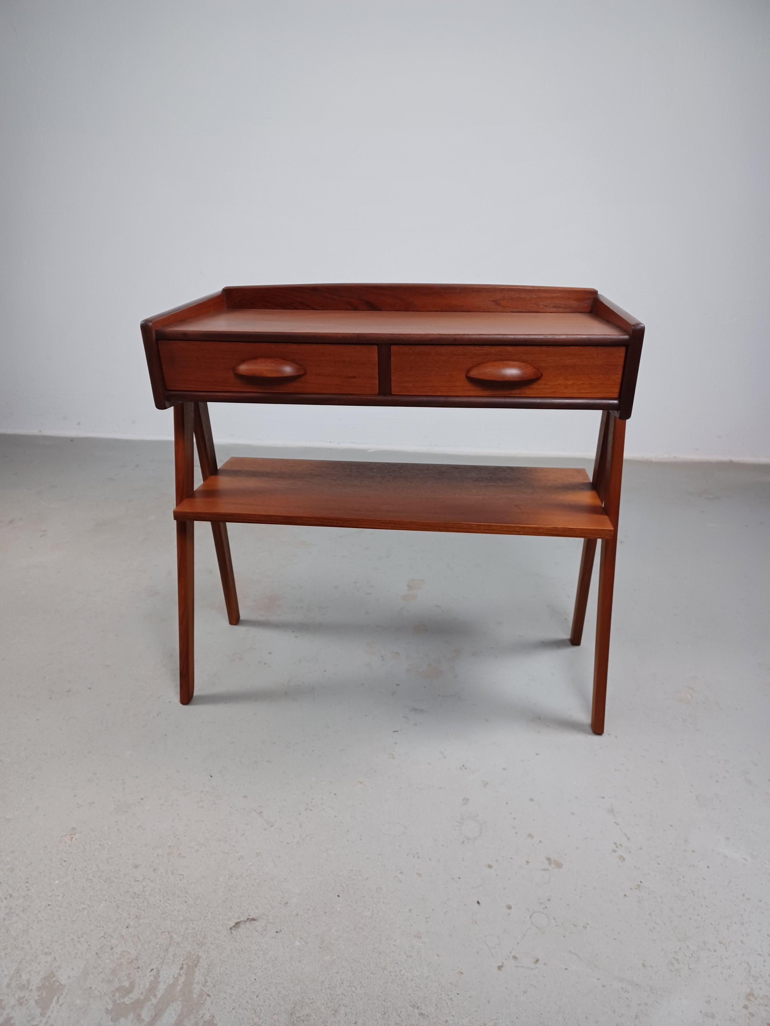 1950s fully restored Danish Røren Rasmussen entry table in teak. - shipping included.

The small entry table feature  a tabletop with two drawers with carved pulls on top of V-shaped solid legs in teak and a teak shelf.

The entry table has been