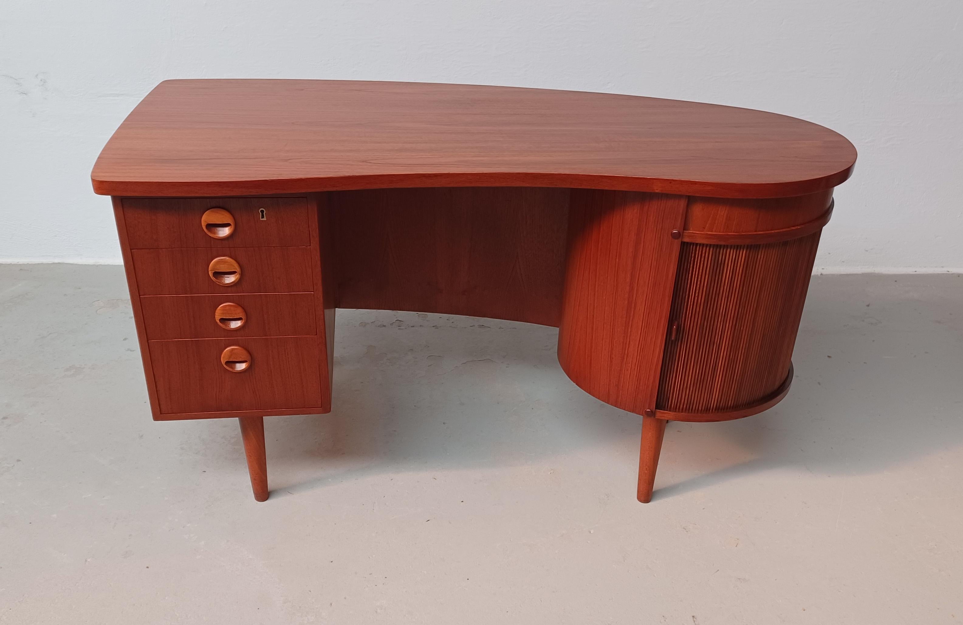 1950's Fully restored executive teak writing desk from Feldballes Møbelfabrik

Exclusive model 54 teak writing desk from the 1950s designed with soft curved lines, bookshelves on the backside, an integrated bar cabinet, and even a hidden drawer...