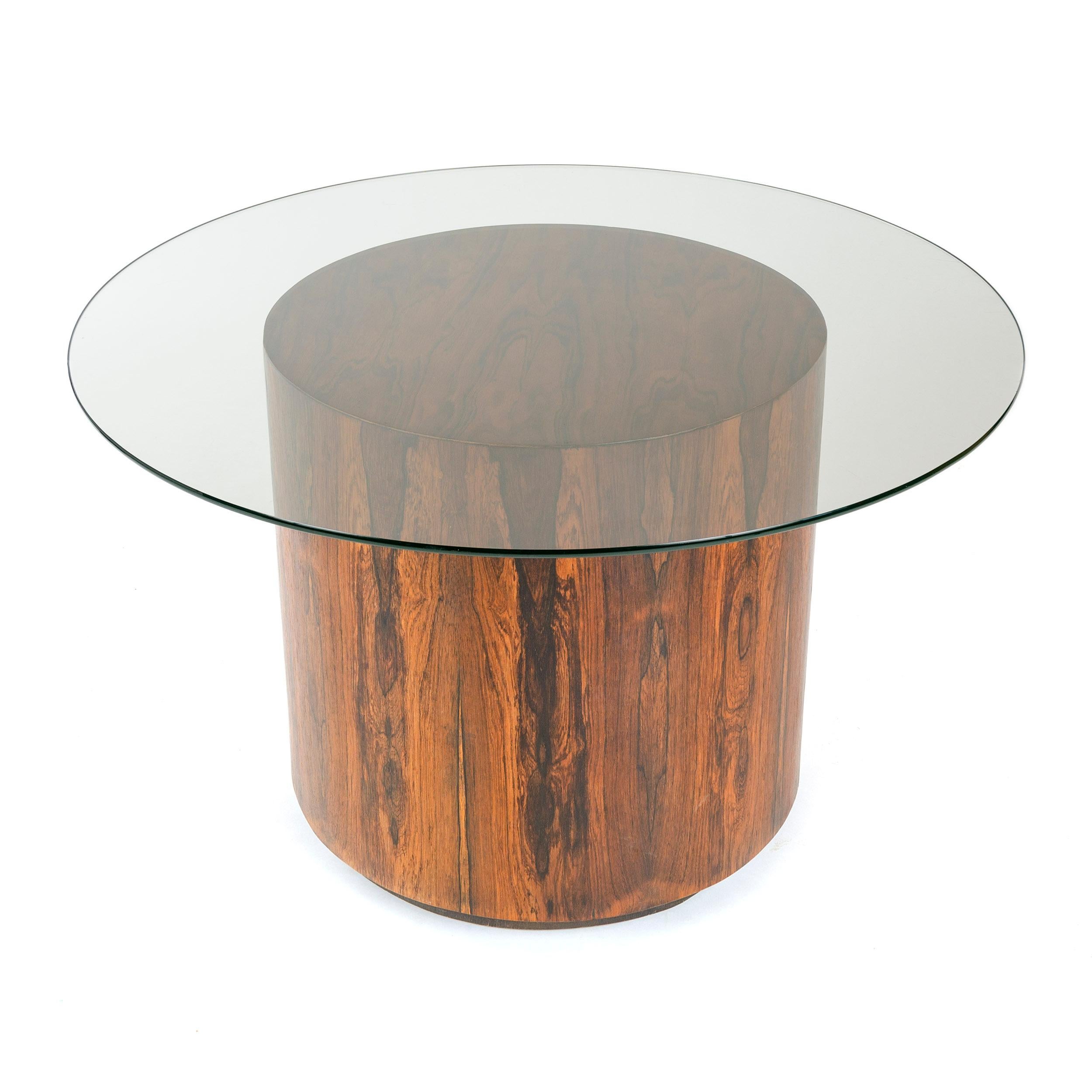 A thick, glass-topped game or dining table with a round veneered base in the style of Milo Baughman.