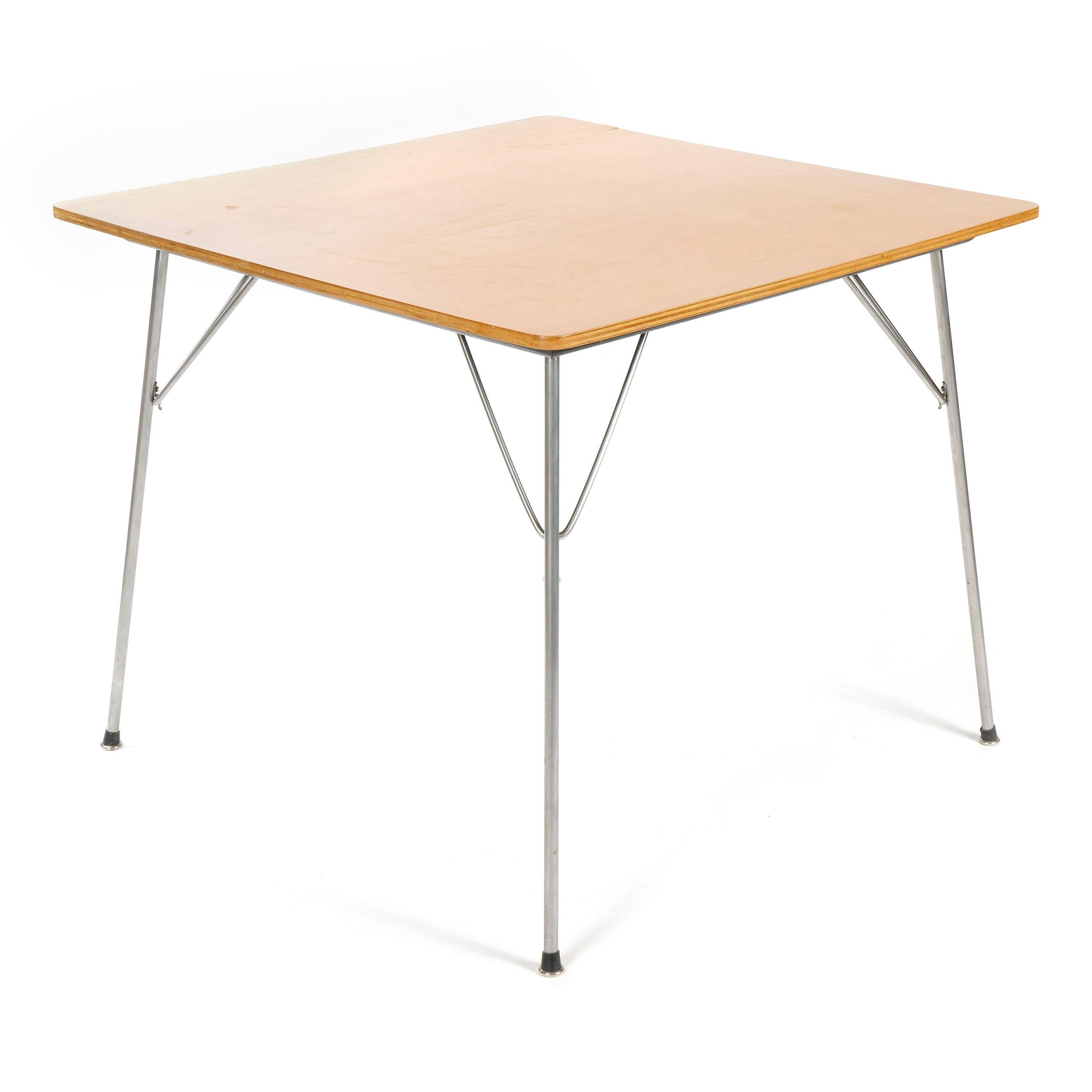 A square dining or game table with an ash top, on folding steel legs. Model DTM.