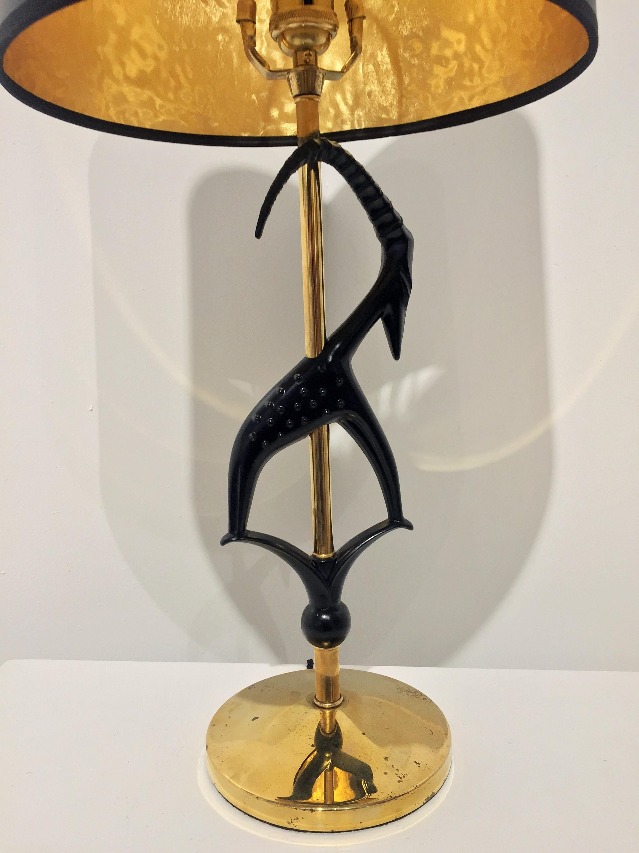 Midcentury gazelle lamp by Rembrandt Lamp Company. The lamp is newly rewired and updated with a brass socket, finial, and black paper shade (inside of shade is gold-like foil and due to its opaqueness, the light is directed up and down). The base
