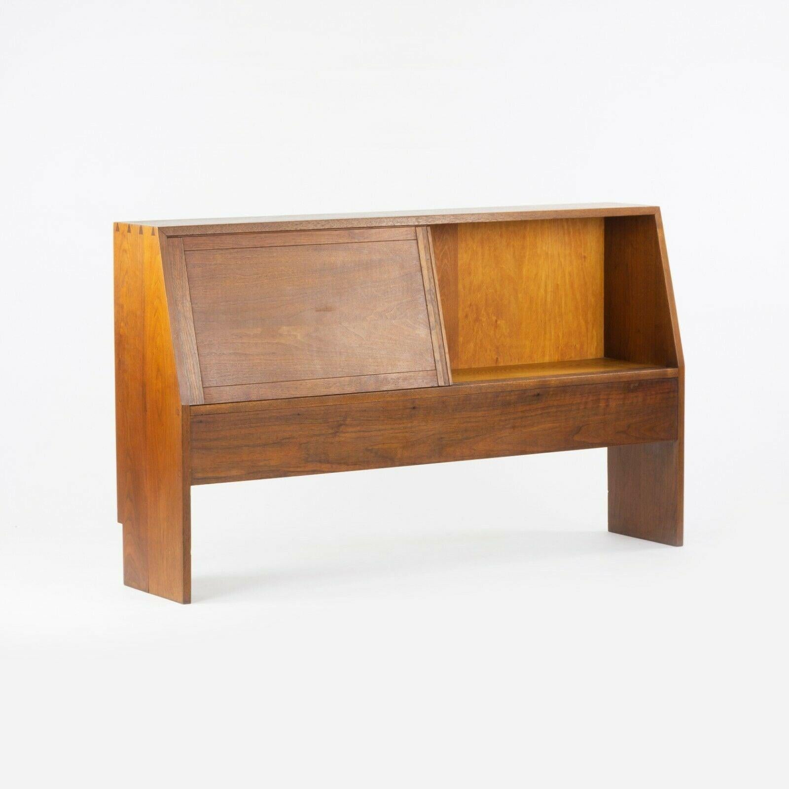 Listed for sale is a very special 1950s George Nakashima headboard, produced at the Nakashima Woodworking studio in New Hope, Pennsylvania. This stunning original example is the variant with a storage compartment and its constructed in solid black