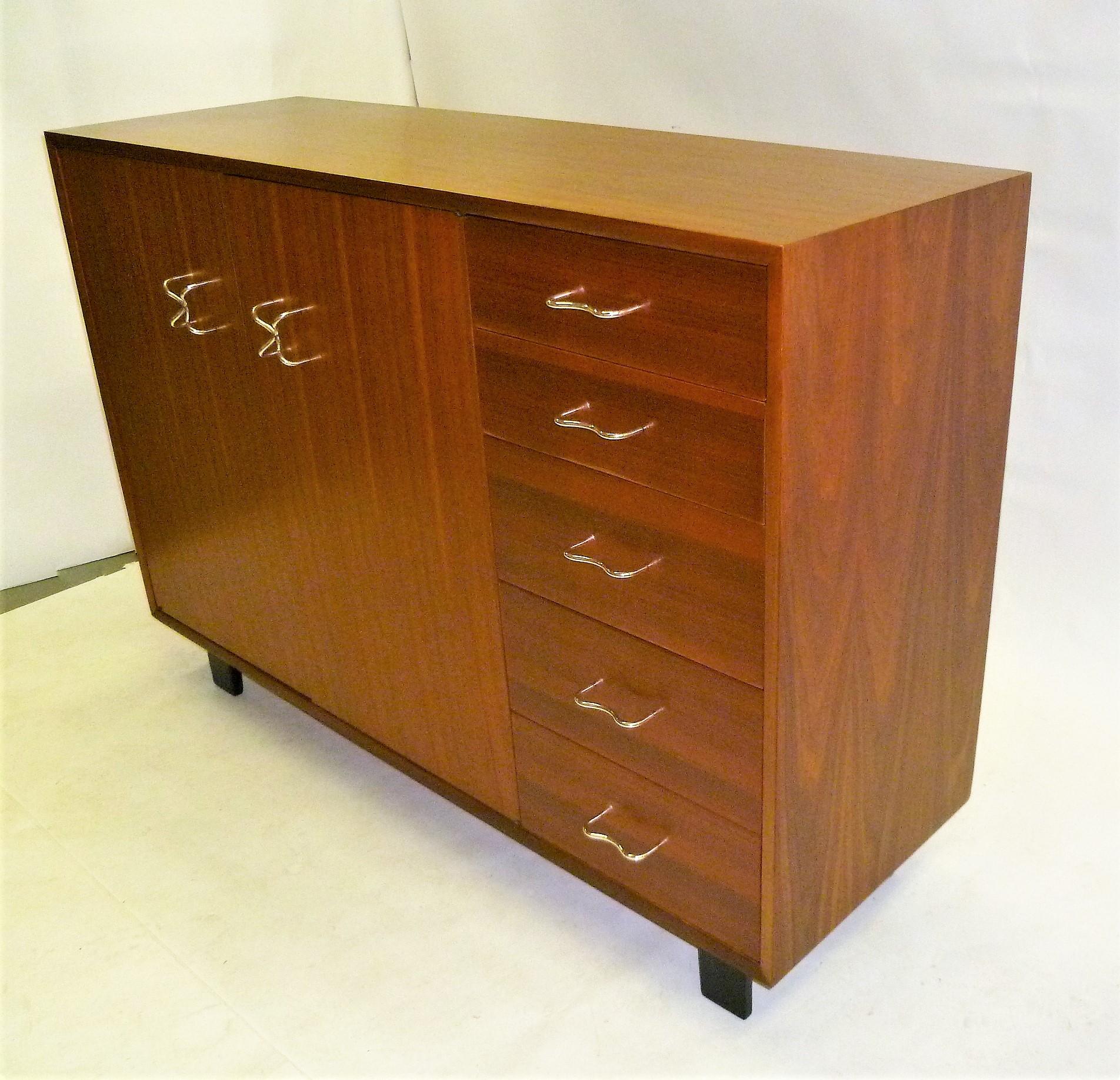 Mid-Century Modern Icon, George Nelson created this wonderfully figured walnut sideboard for the 1952 Herman Miller Collection, Model 4937. Featuring five drawers on the right side and two doors on the left opening to adjustable shelves and two cork