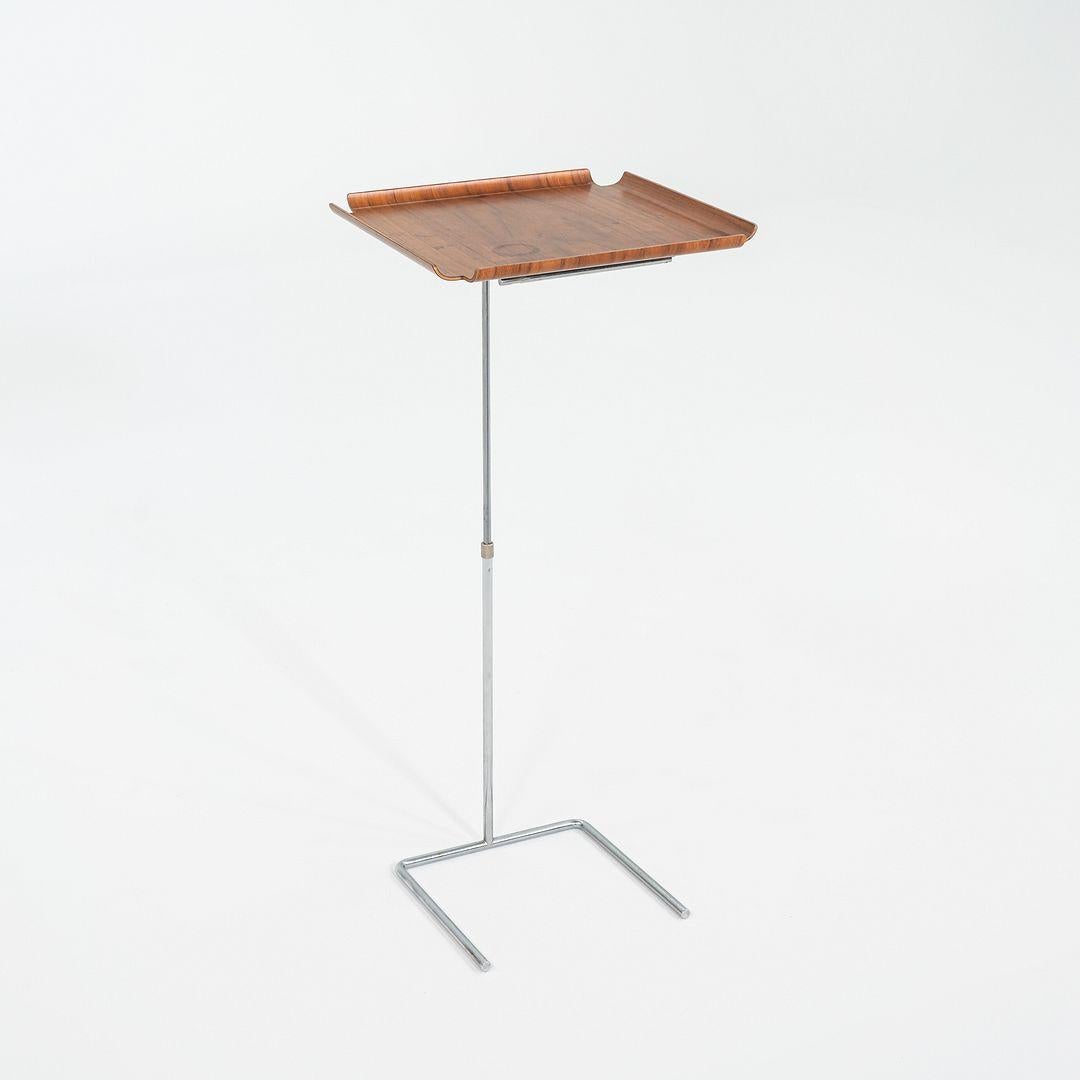 This is a Tray Table, Model No. 4950, originally designed by George Nelson in 1948. This particular example was produced by Herman Miller in the USA circa the 1950s. The design features a molded plywood try atop a chrome steel adjustable base. 

The