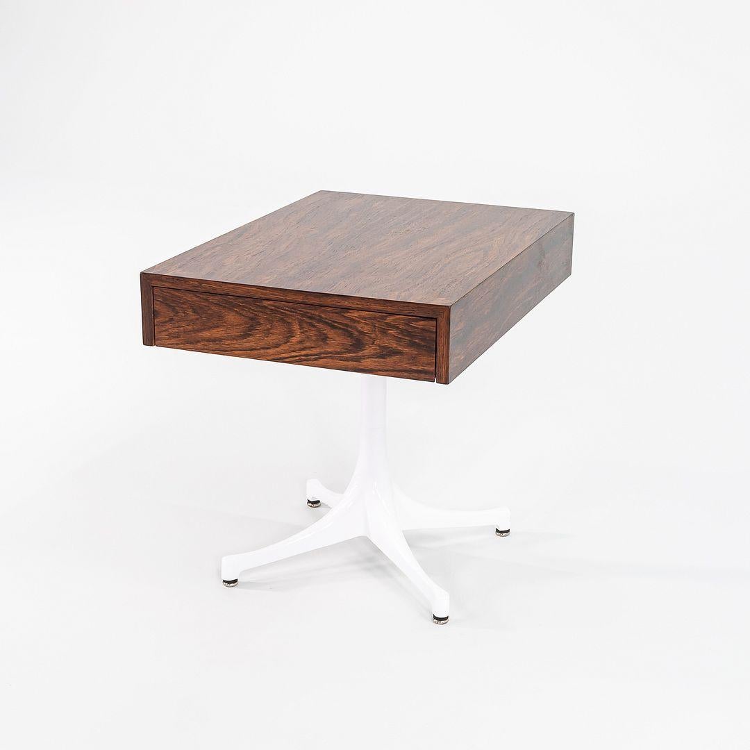 Il s'agit d'une table d'appoint à piédestal, modèle 5655, conçue par George Nelson & Associates pour Herman Miller en 1956. La pièce a un boîtier en bois de rose brésilien et un socle en aluminium émaillé blanc. Il comporte un tiroir. La base a été