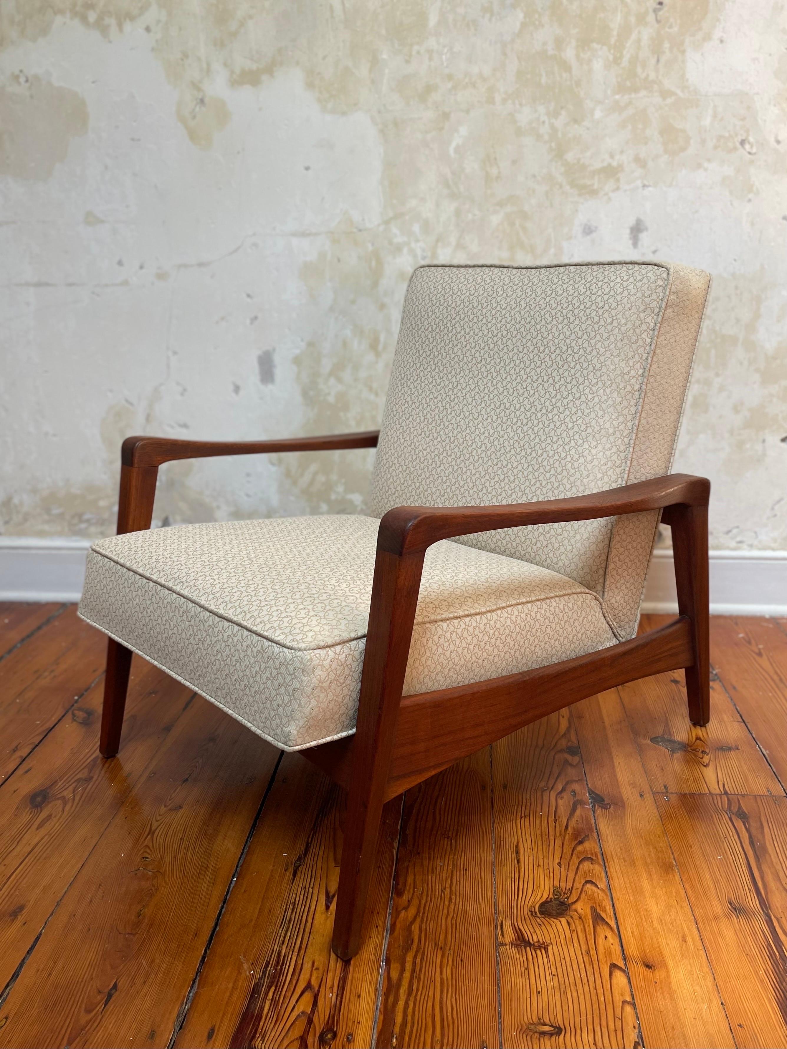 An uncommon (unmarked) model 5476 lounge chair in walnut, designed by George Nelson for Herman Miller. As pictured in the 1955-56 trade catalog in the Grand Rapids Public Museum digital archives. Fabric is a pale yellow/ivory color with a subtle