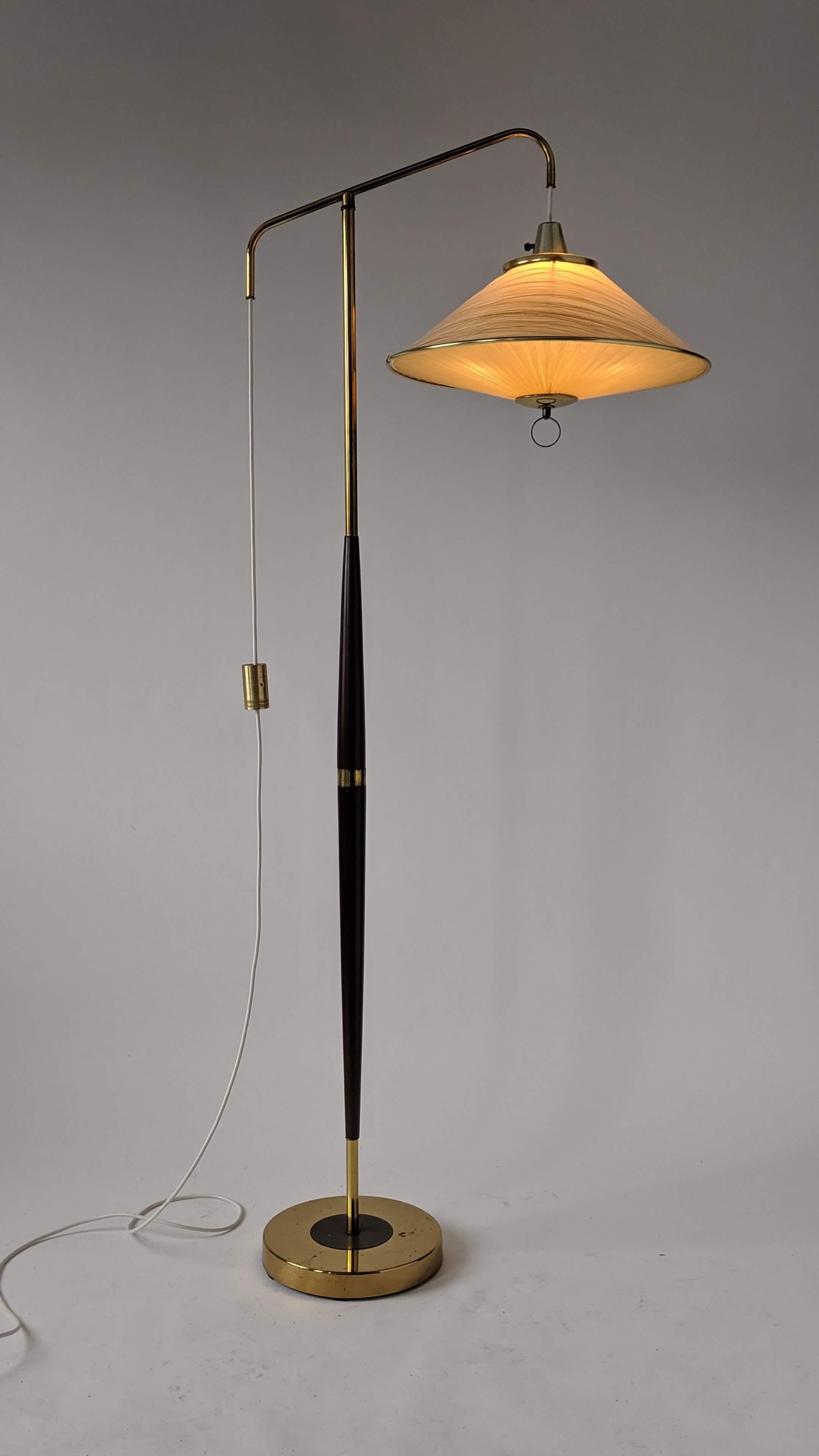 Well made, solid construction brass and walnut floor lamp with height adjustable shade. 

Counter weight mechanism work extremely well.

Original plastic shade and diffuser. Measure 19 in. wide by 12 in. high.

Rotating on/off switch on