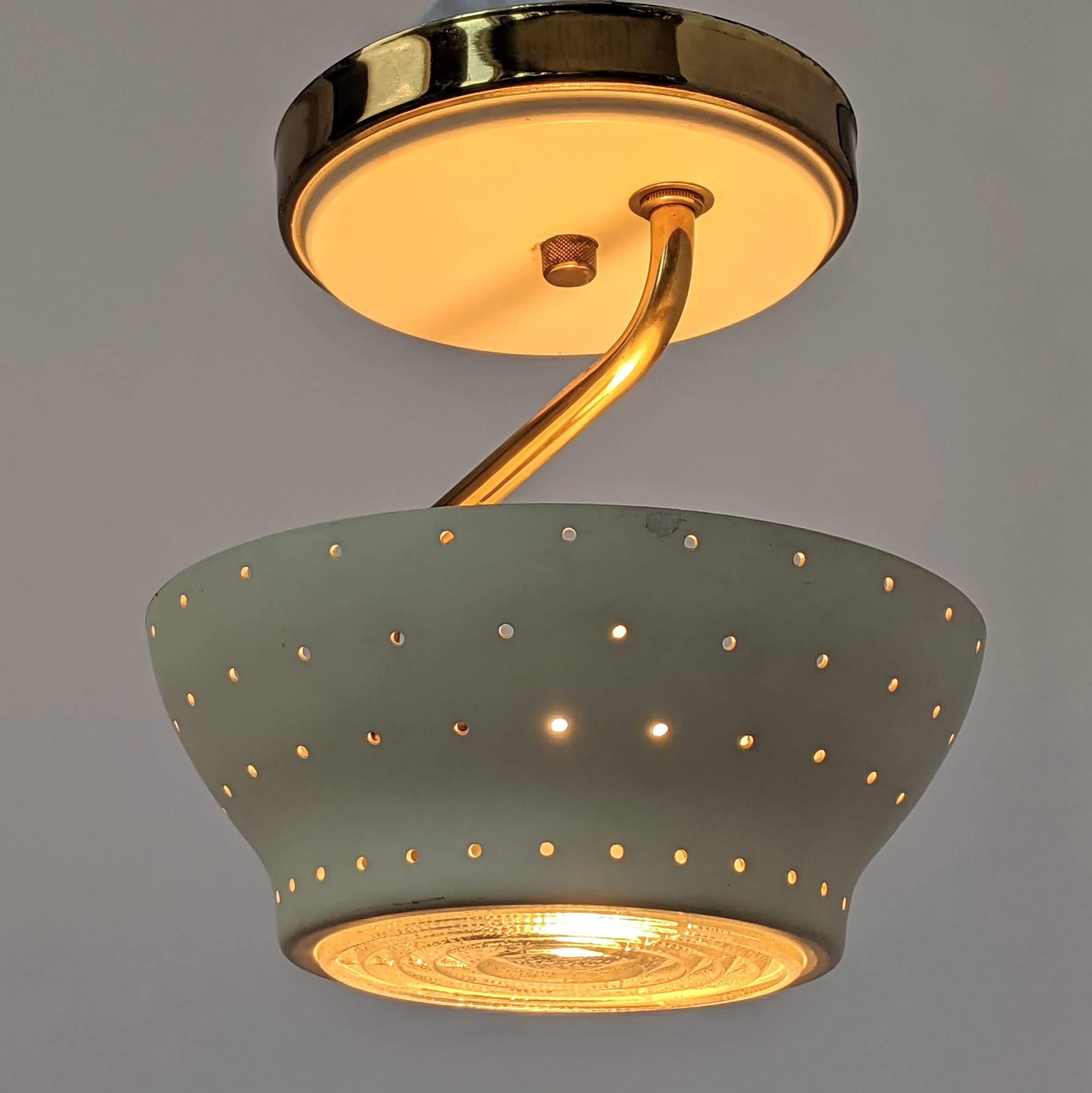 Enameled aluminium pierced shade flush mount with brass arm and thick glass lens diffuser.  

Solid well made construction.

E26 size socket rated at 60 watt.