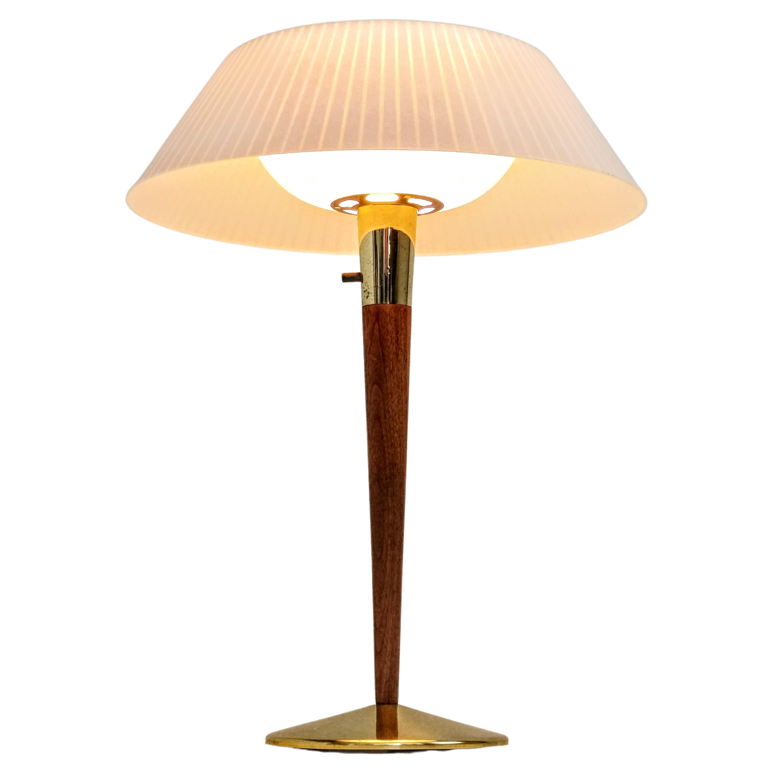 Elegant table lamp made of walnut, brass with plastic shade.

By Gerald Thurston for Lightolier.

Marked.