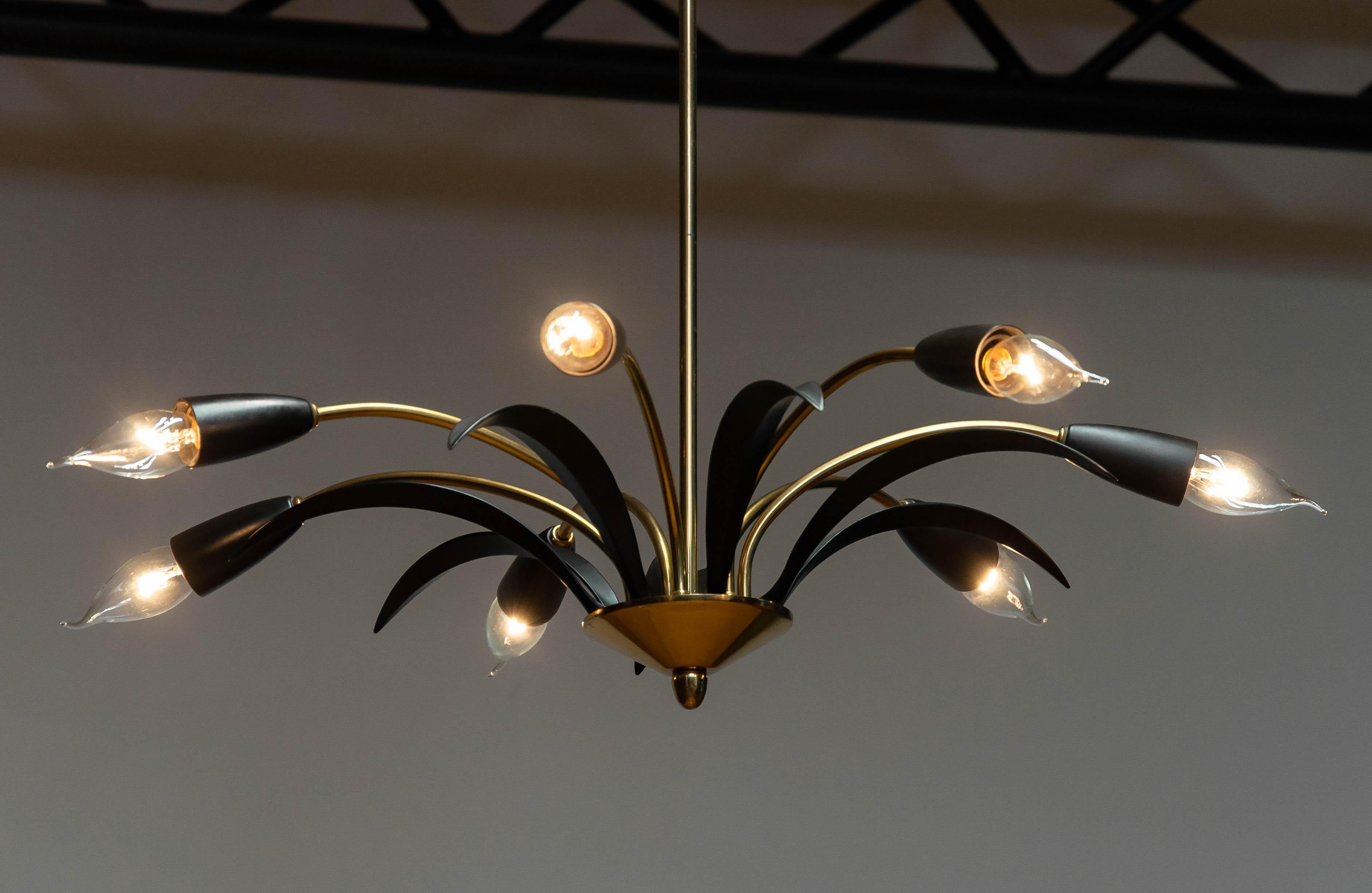 Beautiful spider chandelier from the 1950s made in Germany. Seven E14 screw fittings are mounted on each end of the brass legs and between the legs are leafs made of metal.
Allover this spider / sputnik is in good condition and technically 100%. It