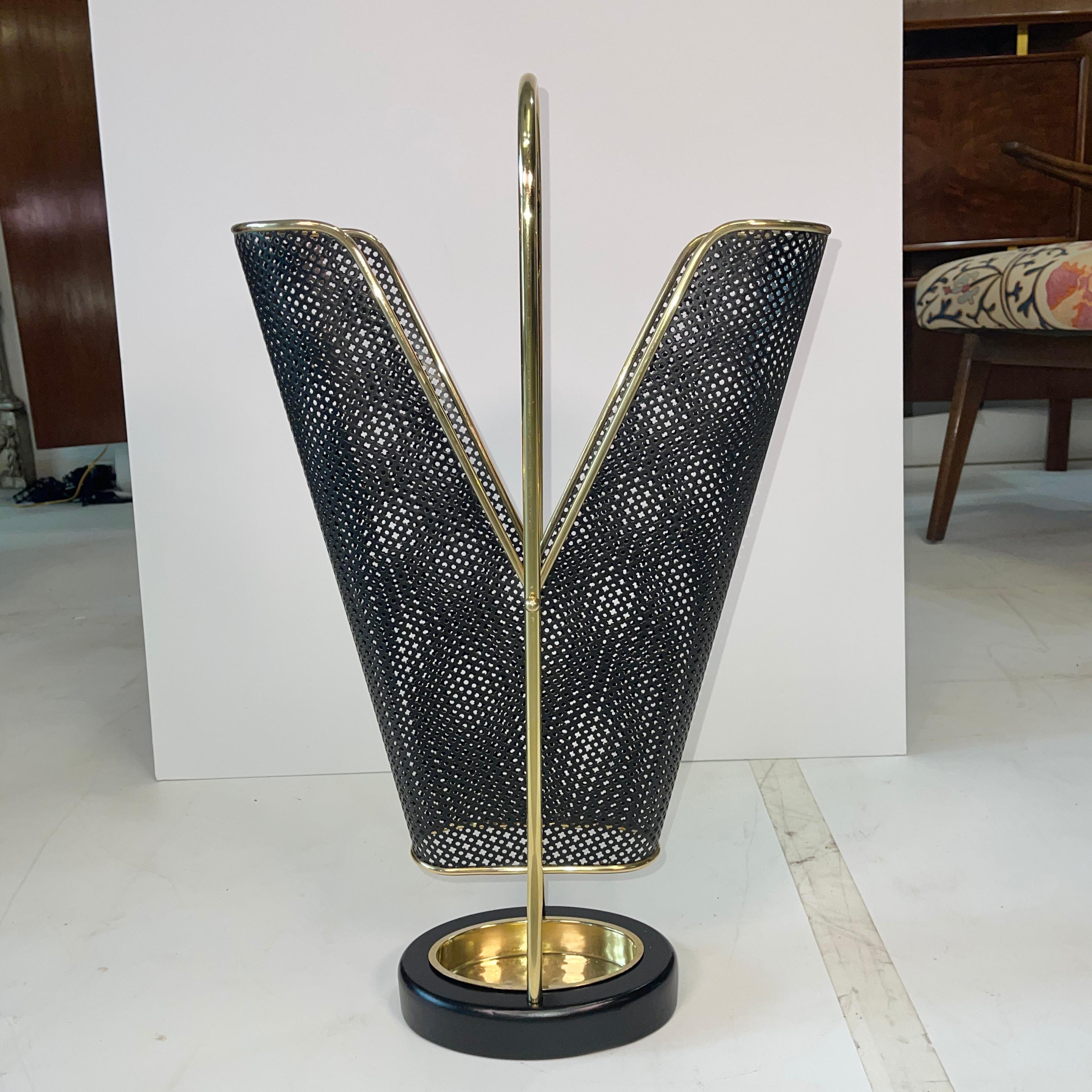 1950's German umbrella stand in brass and black enemaled perforated metal produced by Vereinigte Werkstätten München (United Workshop for Arts and Crafts).
Very well constructed as well as seriously chic.
The cast iron oval donut hole base is