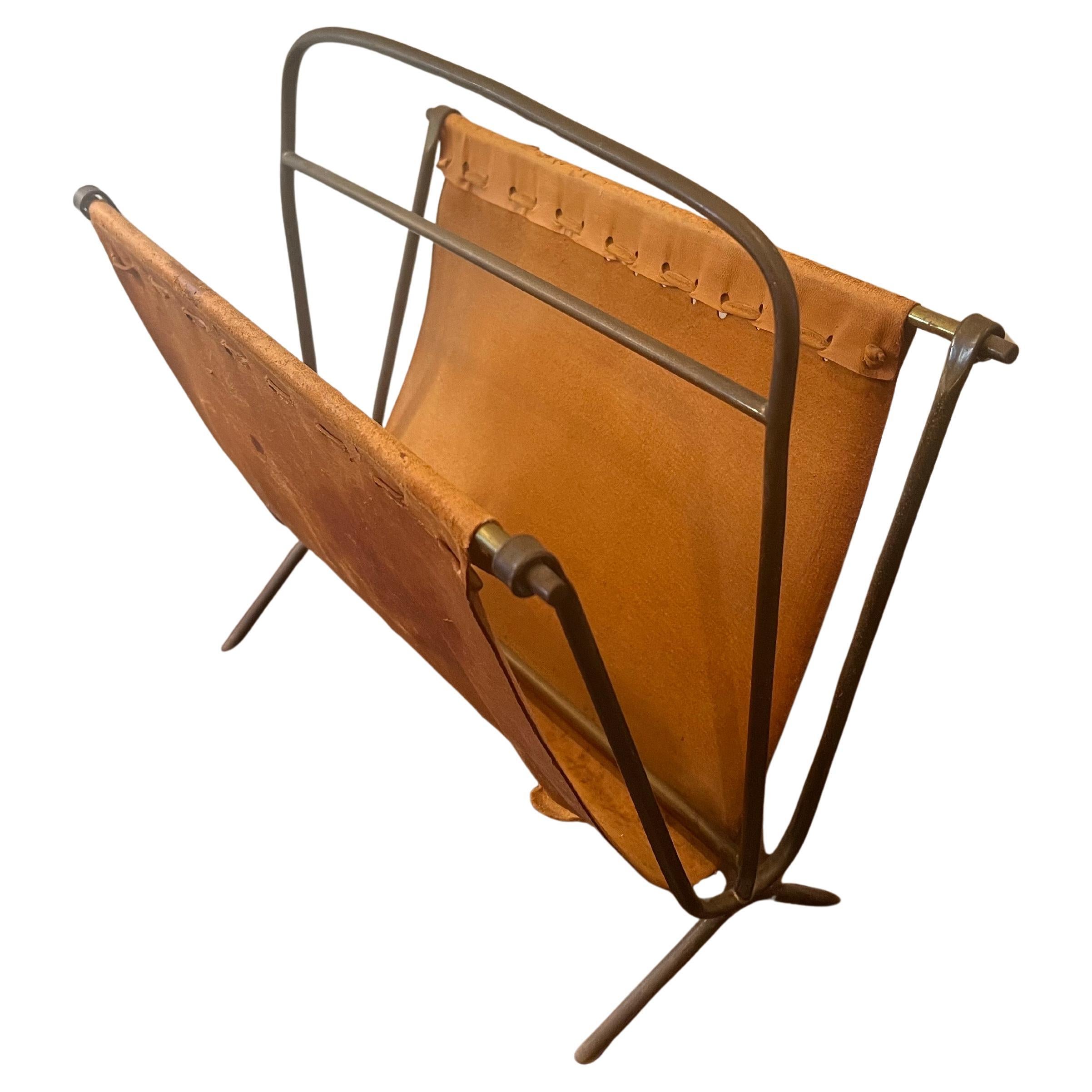 Un rarissimo portariviste in ottone patinato e pelle, risalente agli anni '50 circa, acquistato in Germania. La pelle presenta macchie e strappi, come mostrato, e viene venduta nelle condizioni in cui si trova. L'ottone è un po' piegato.