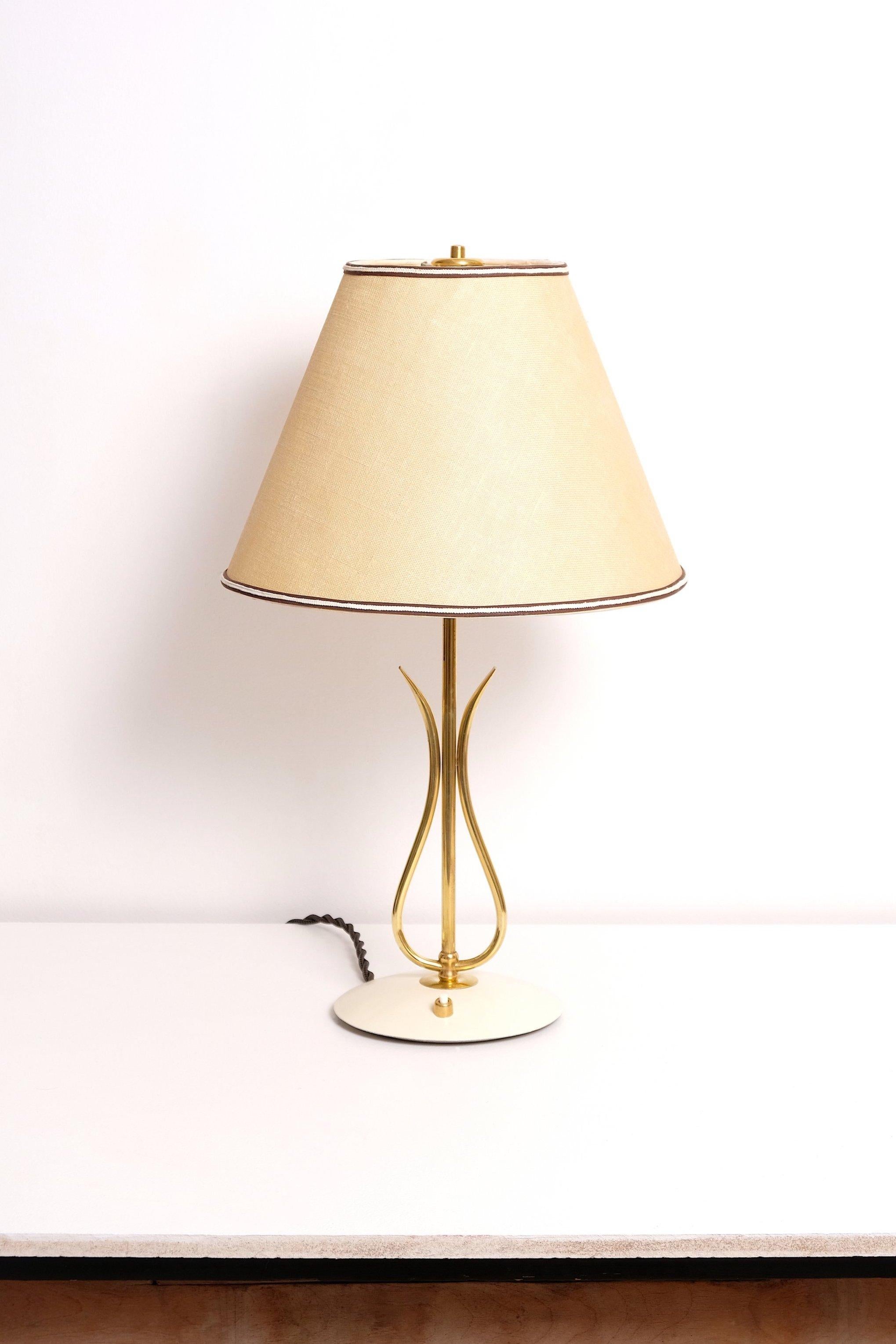 Table lamp made in German. Polished brass stem and foot, paper backed cloth shade. 40-60 watts E-26 Edison medium base incandescent bulb recommended or higher if LED/CFL.

Rewired with new E-26 medium base socket and rewired with 18/2 plastic cord,