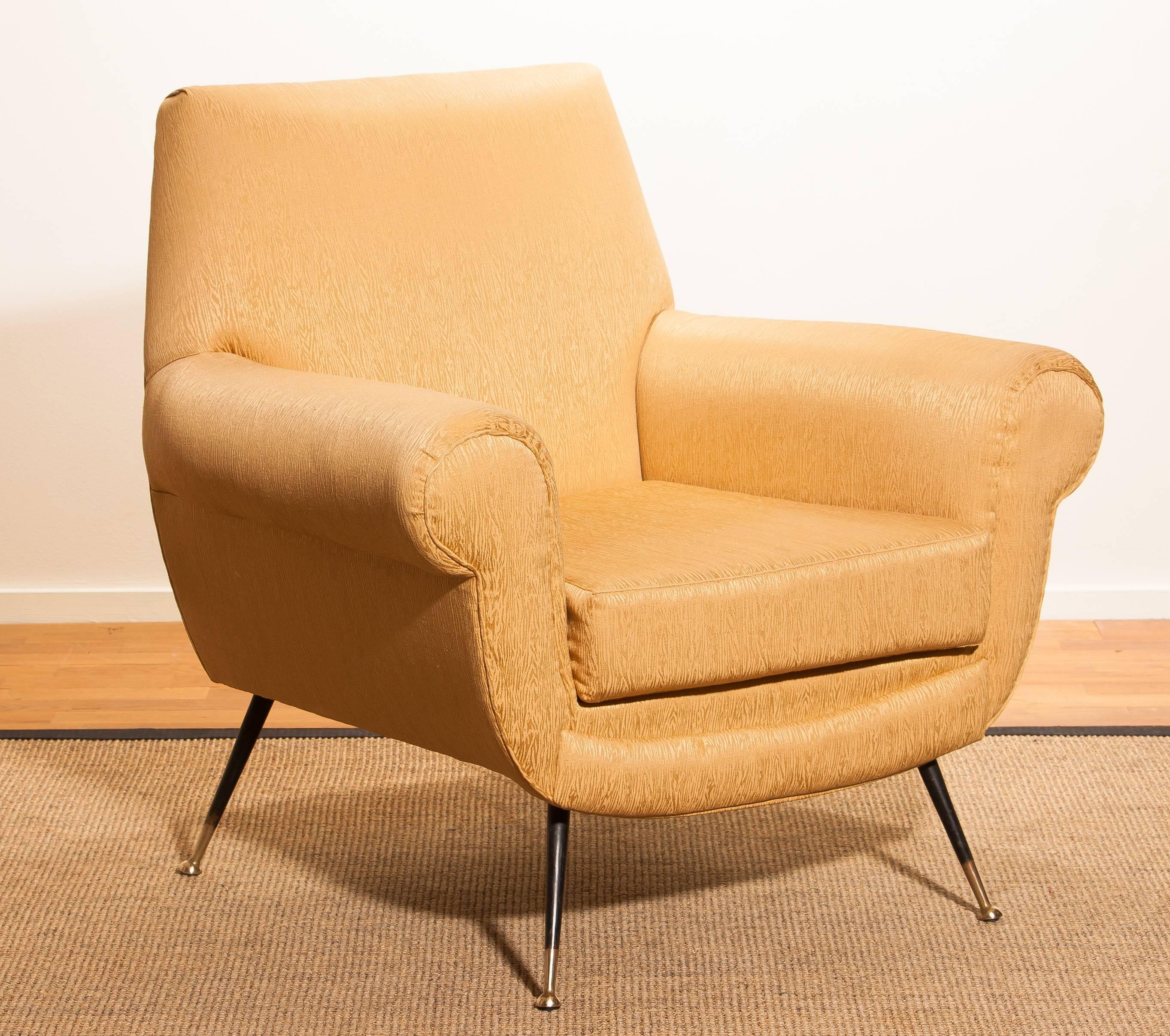 Beautiful and excellent Italian midcentury lounge chair of the 1950s. With the original brass stiletto legs and golden jacquard fabric (later period), all in perfect condition and with an extremely comfortable seat. Designed by Gigi Radice for