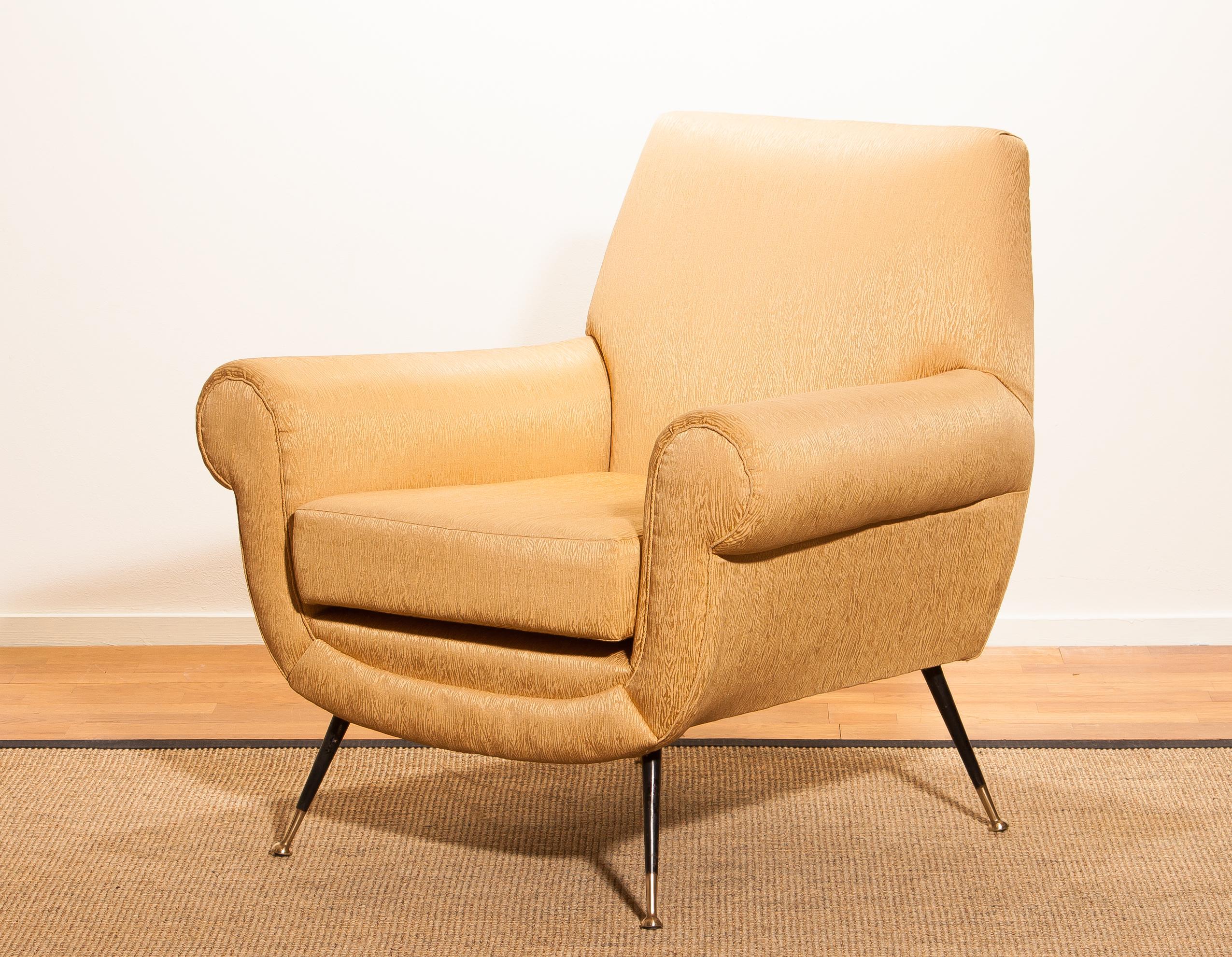 Beautiful and excellent Italian midcentury lounge chair of the 1950s. With the original brass stiletto legs and golden jacquard fabric (later period), all in perfect condition and with an extremely comfortable seat. Designed by Gigi Radice for