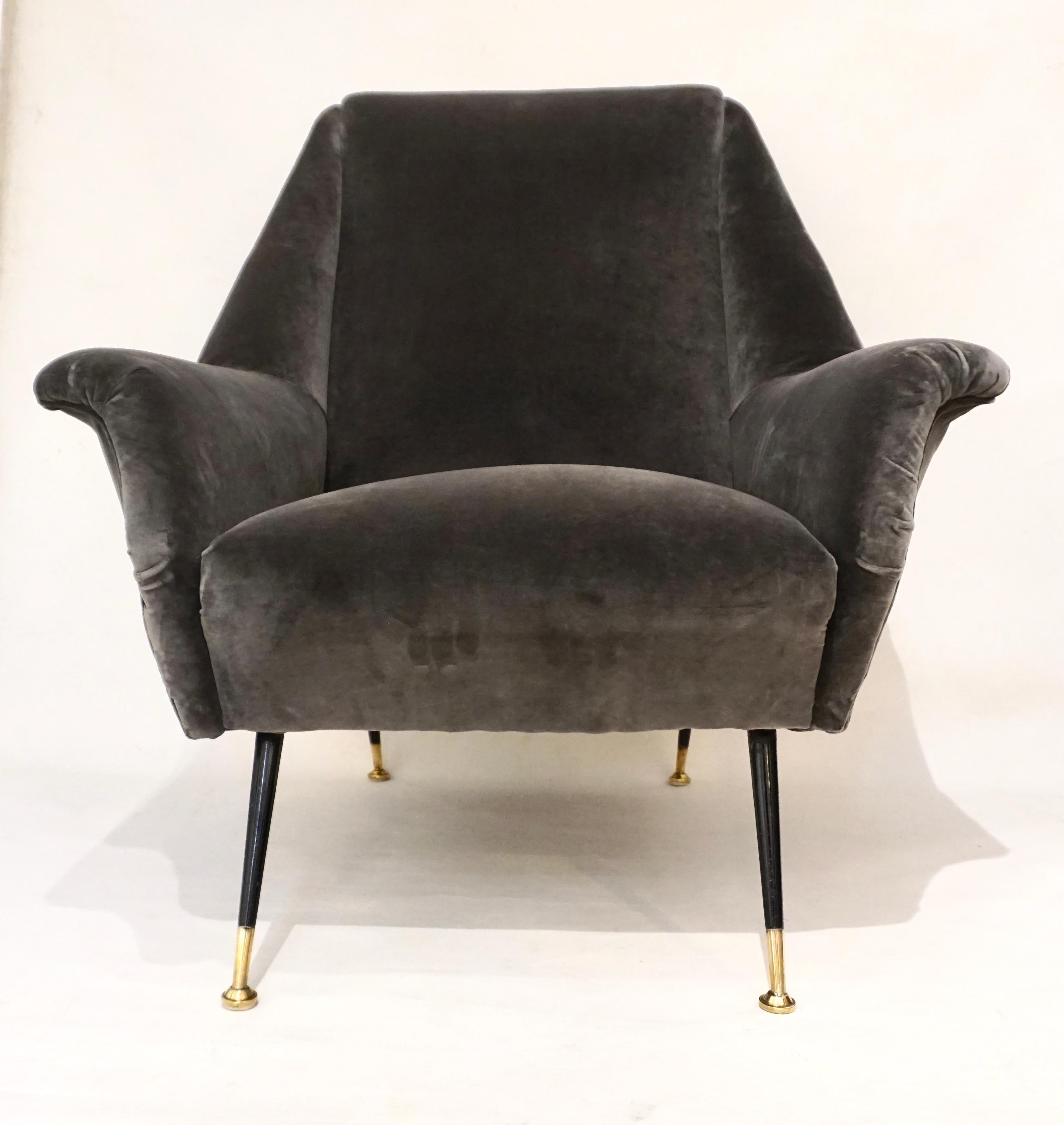 An elegant Italian Mid-Century Modern pair of very comfortable living room armchairs of great execution, by Gigi Radice for Minotti. The design is superb with a slightly curved large back and the side edges protruding to create the armrests and to