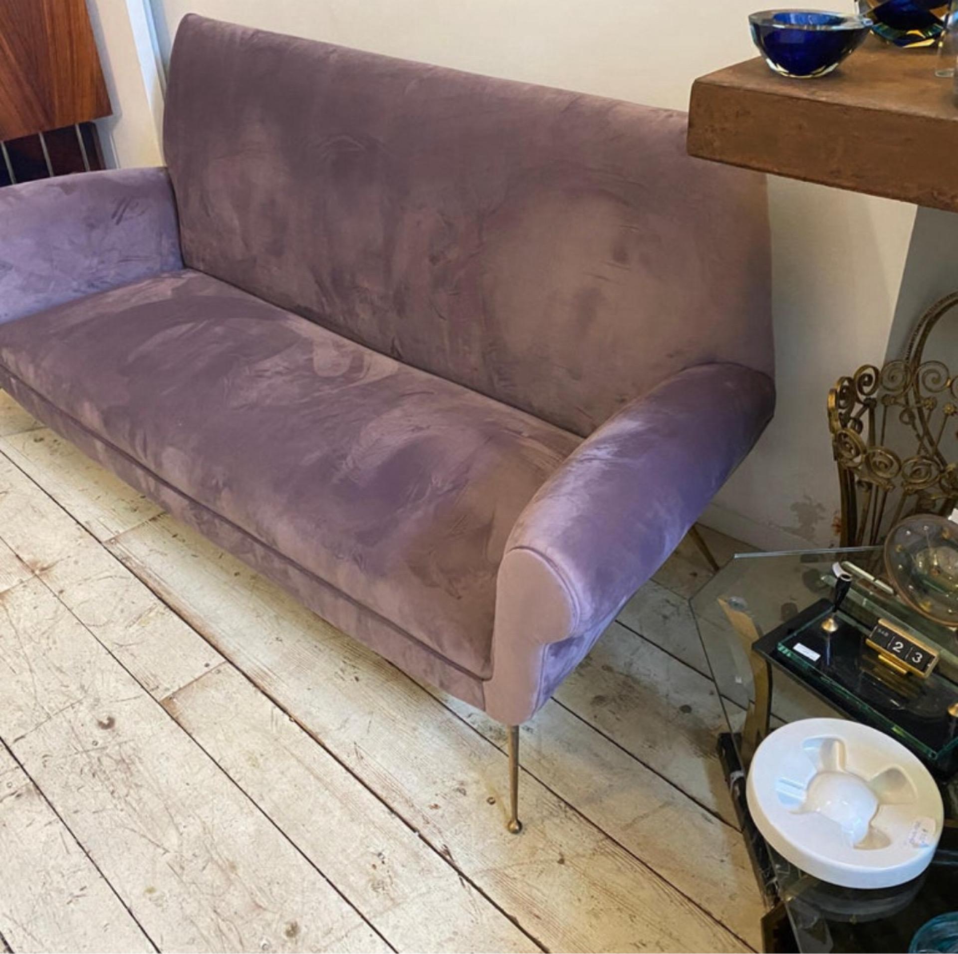 A stylish Mid-Century Modern sofa designed and manufactured in Italy in the Fifties, brass it's in original patina, wisteria velvet has been recently upholstered, it's a luxurious and iconic piece of furniture. Its combination of plush wisteria