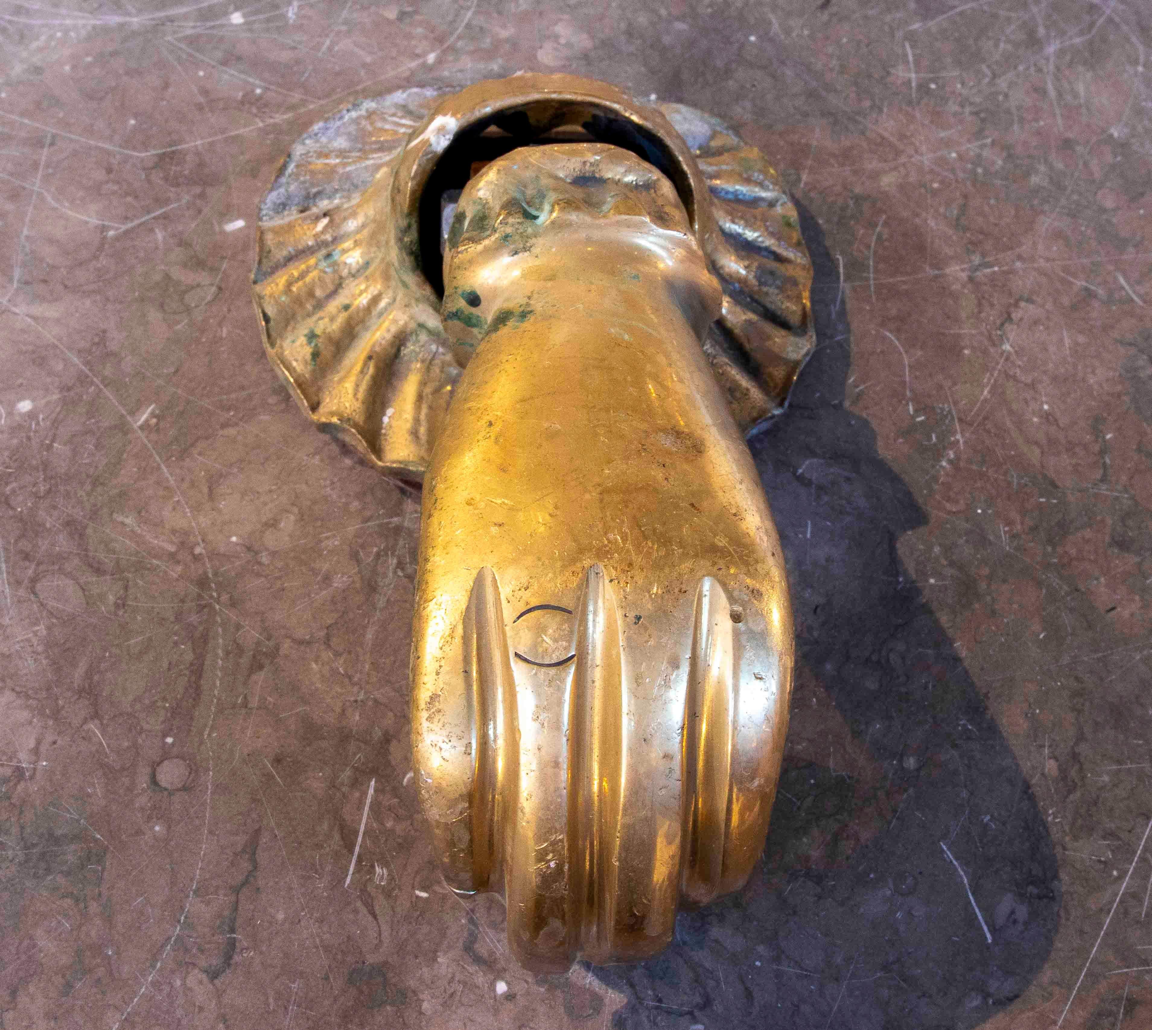 Prächtiger Türklopfer in Form einer Frauenhand, aus massiver Bronze gegossen und vergoldet. Ein authentisches Stück aus dem 19. Jahrhundert, das die traditionelle europäische Handwerkskunst repräsentiert. Die Hand hält einen kleinen Ball, ein Symbol