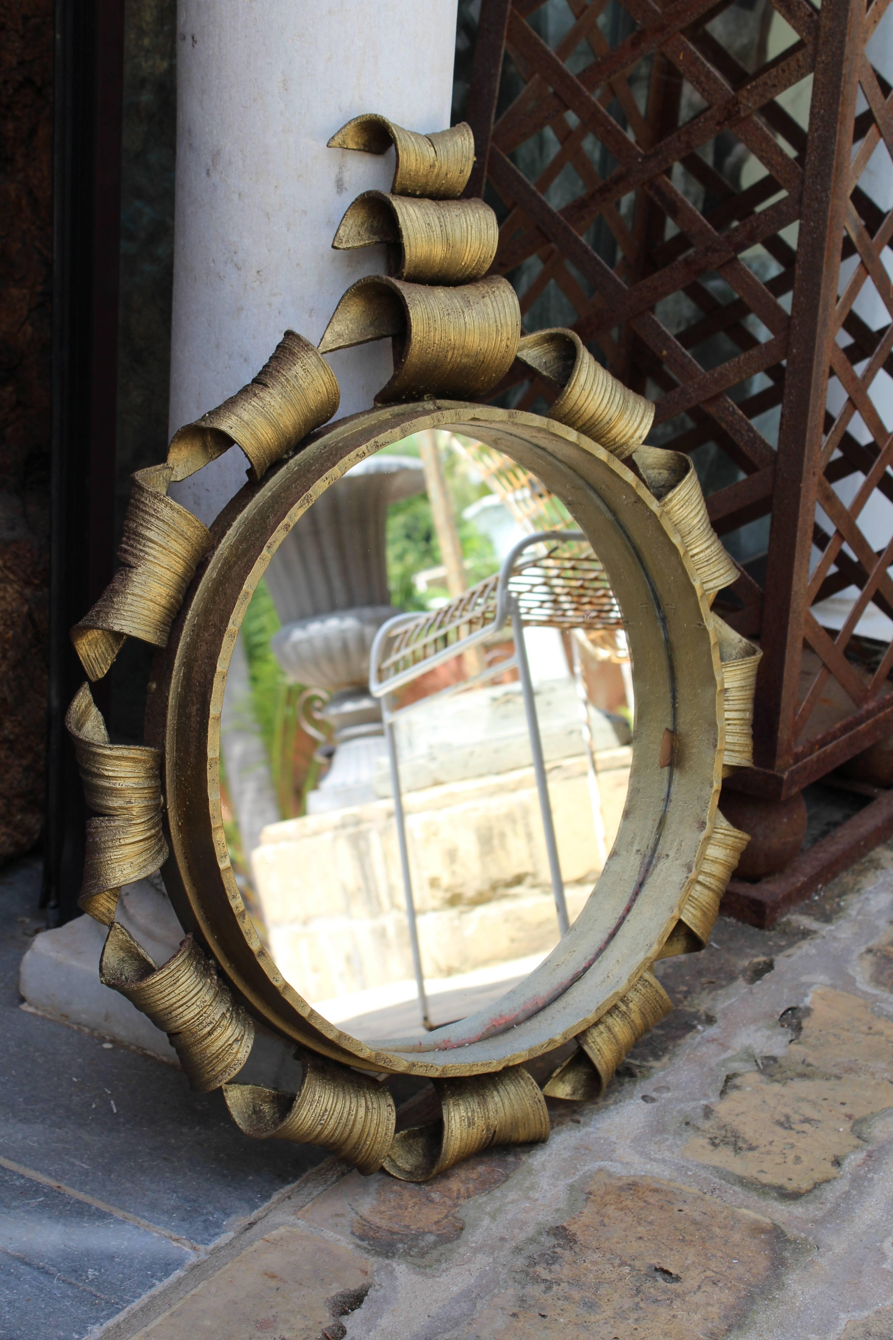 1950 gilded forged iron mirror framed with scrolls and topped by a triple roll crest.
 