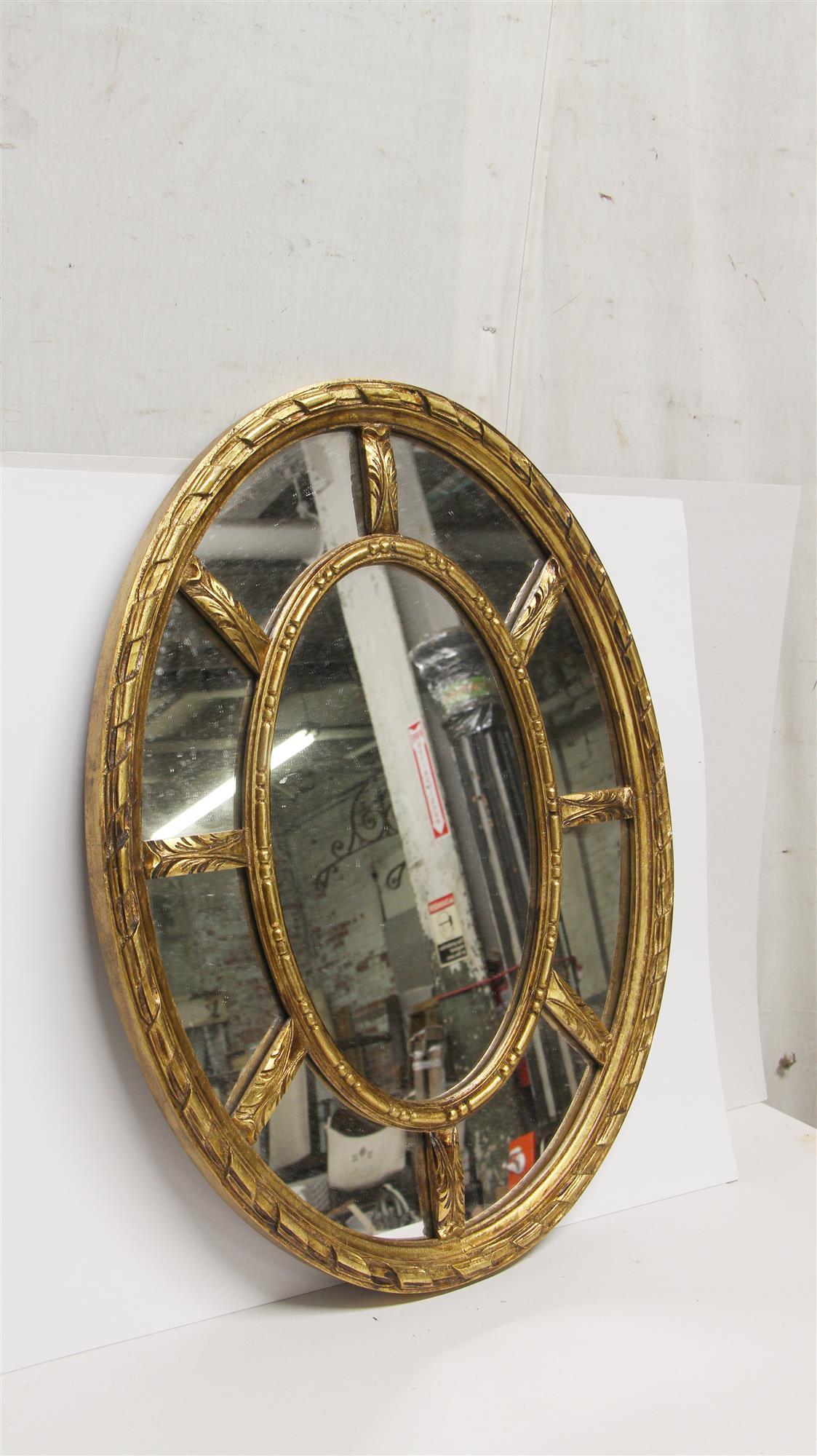 1950s French oval shaped wall-mounted mirror with a gilded frame. This can be seen at our 333 West 52nd St location in the Theater District West of Manhattan.