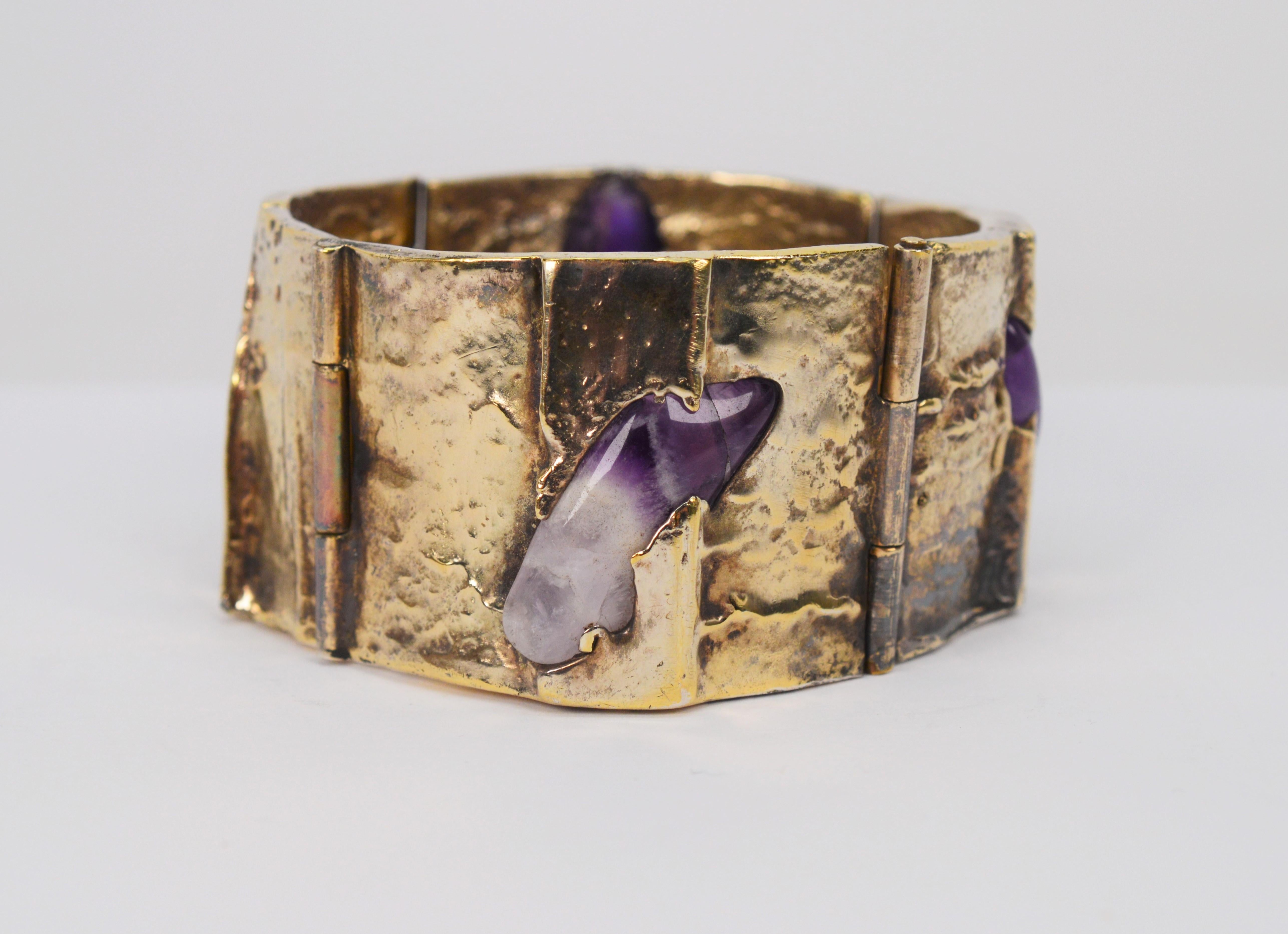 Eclectic and stunning describes this rustic wearable art bracelet with natural amethyst quartz stone. Craftsman made of four hand hammered hinged panels of 500 toned silver and gilded to enhance the outstanding natural beauty of the imbedded polish