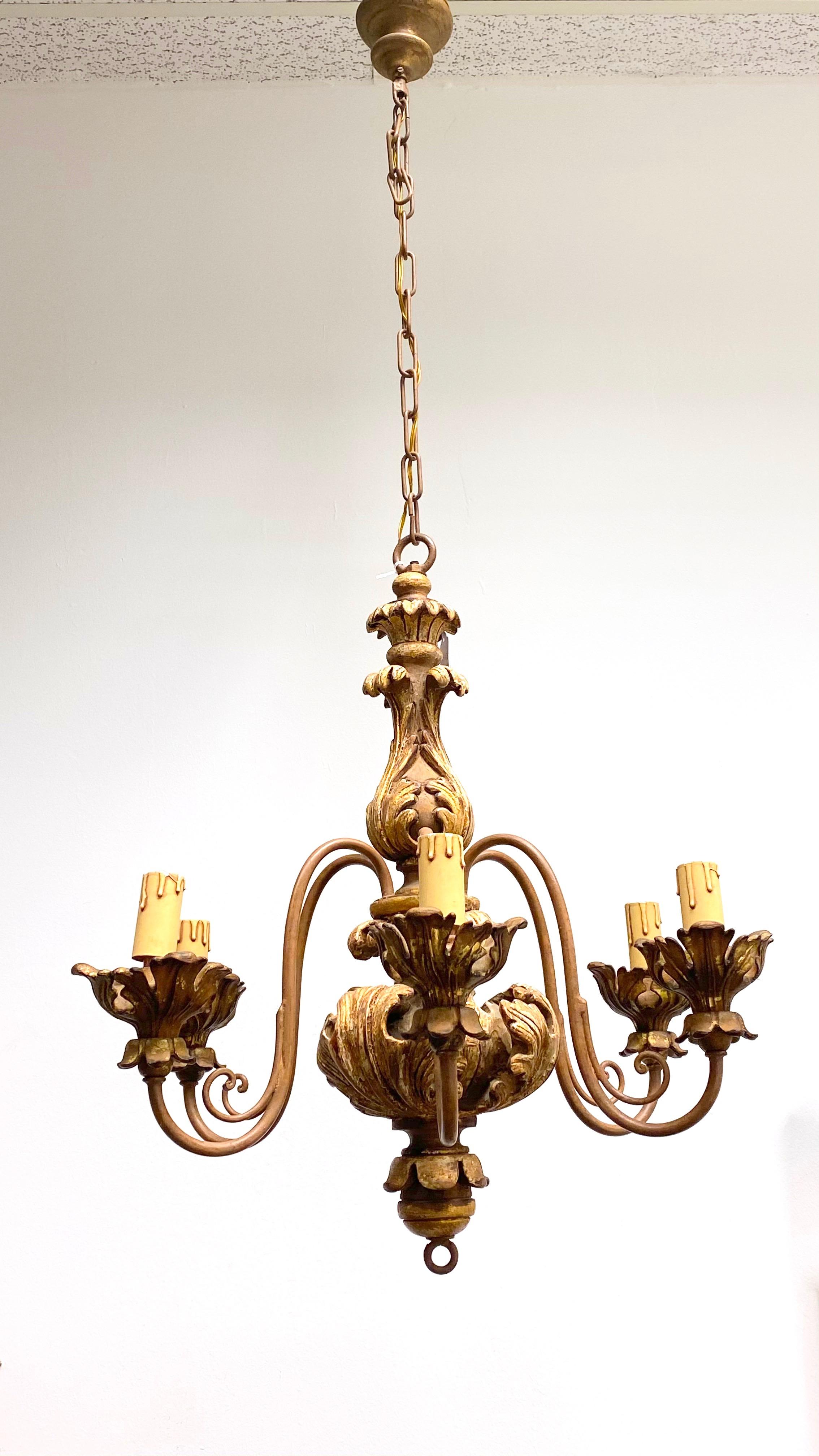 Add a touch of opulence to your home with this charming chandelier! Perfect acanthus leaves on a gilt wood and metal chandelier to enhance any chic or eclectic home. We'd love to see it hanging at a dinning place as a charming welcome. The chain