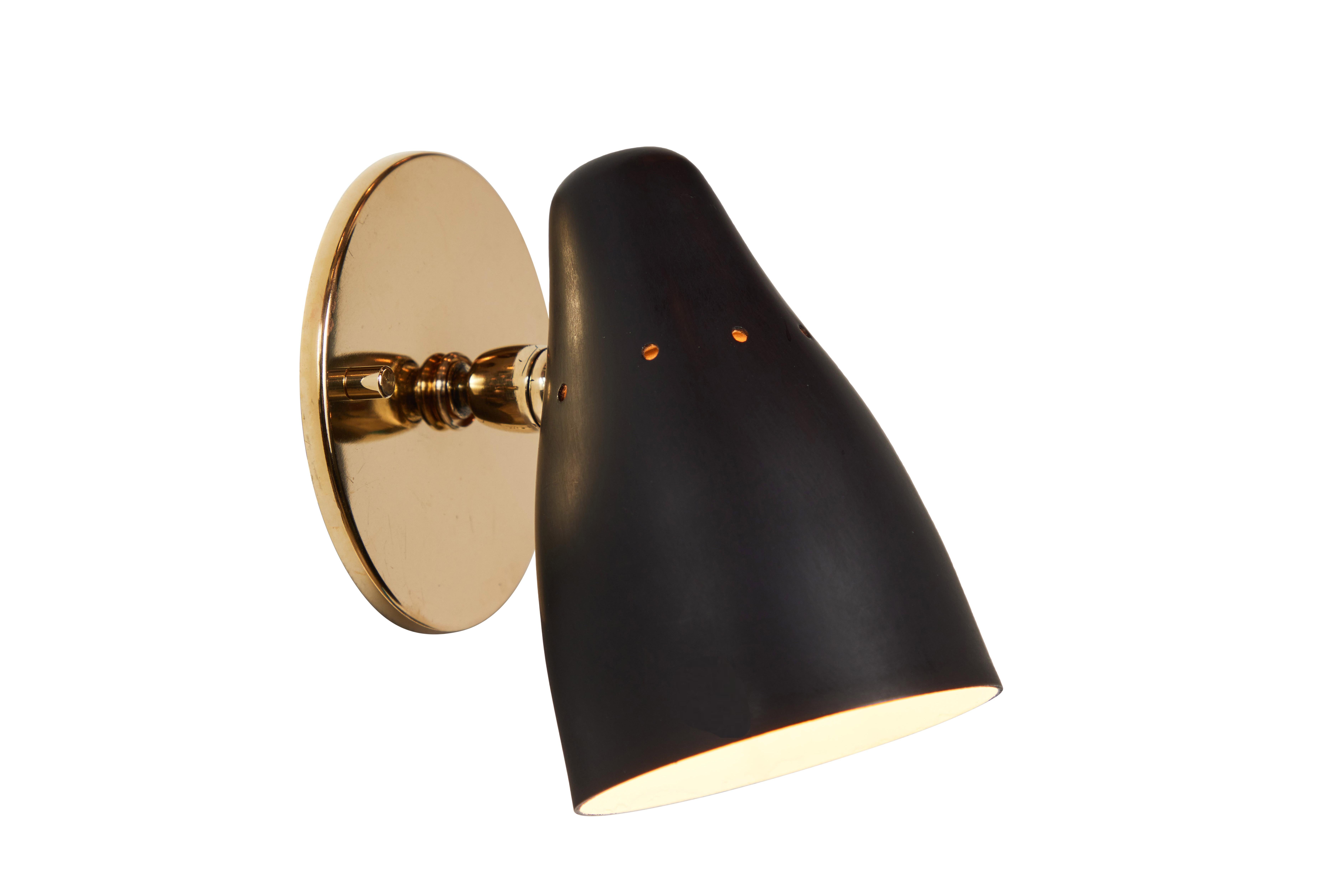 1950s Gino Sarfatti articulating sconce for Arteluce. Executed in black painted perforated metal and brass. Ball jointed arm connection to shade allows for flexible shade adjustments and multiple configurations. The simplicity of Sarfatti's design