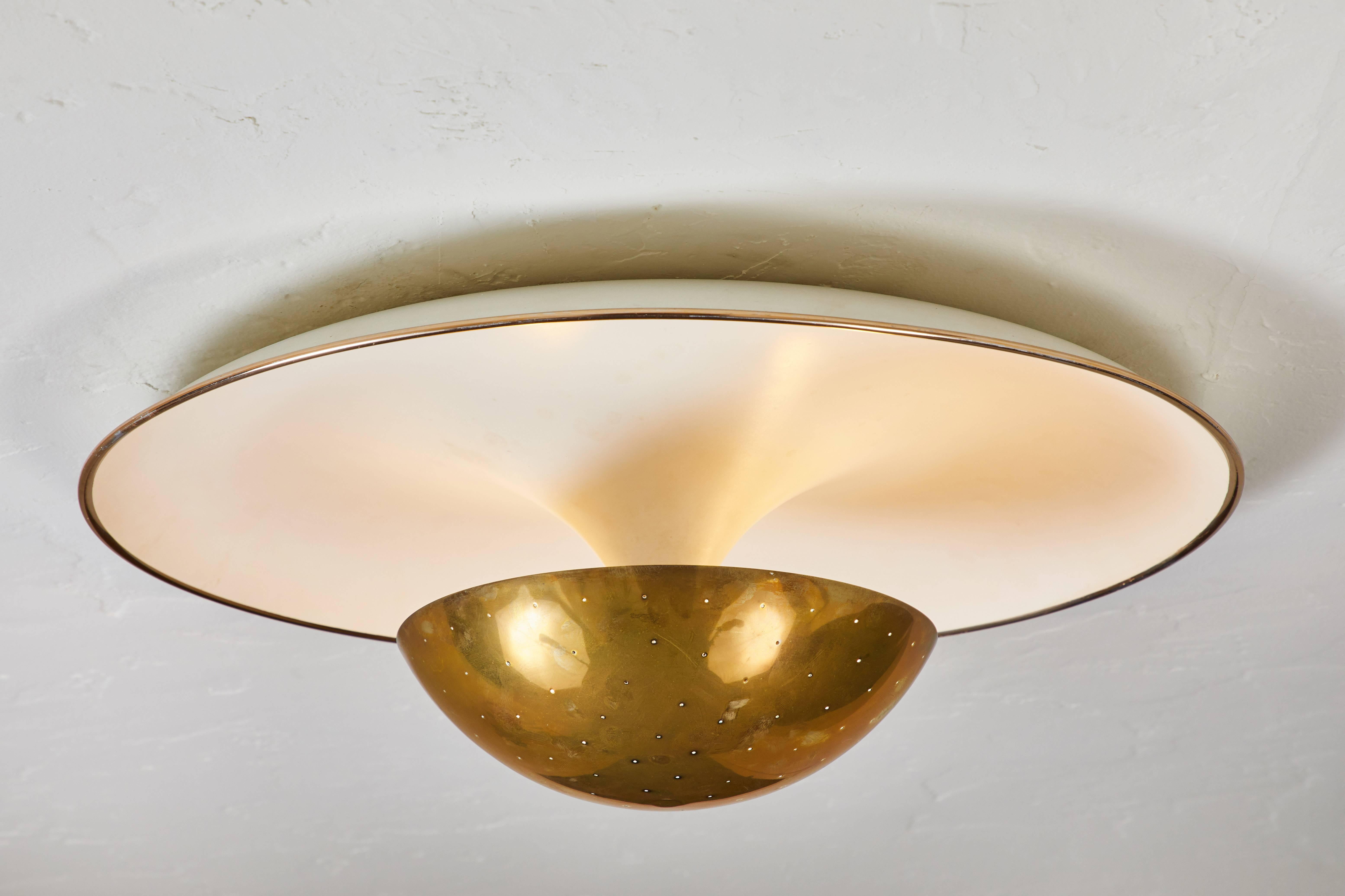 1950s Gino Sarfatti ceiling lamp model #155 for Arteluce. A perforated brass dome on a white painted metal curved plate with a brass detail on the edge. An extremely attractively scaled ceiling or wall light of incomparably refined design. Arteluce