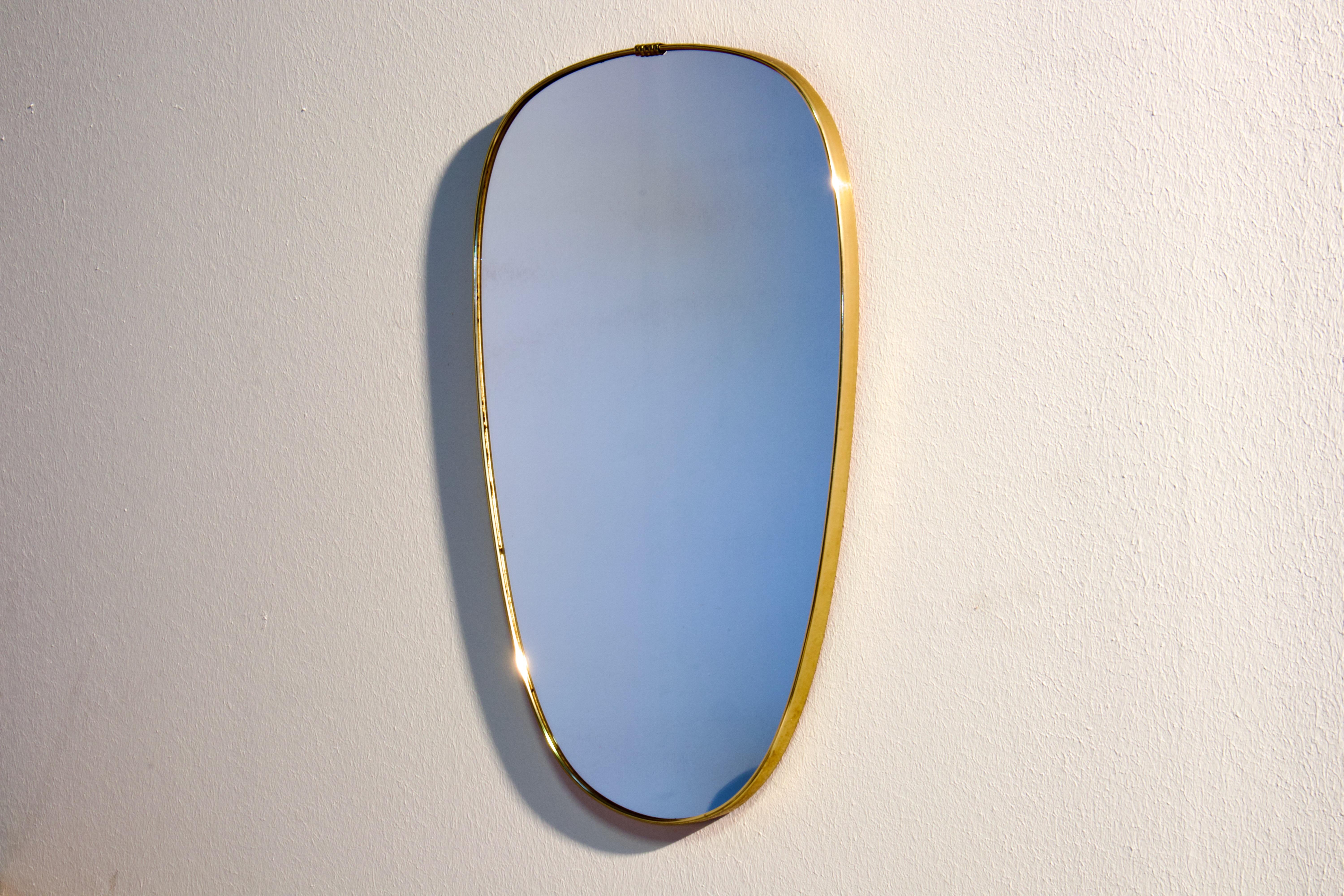 Gio Ponti era Mid-Century Modern wall mirror in patinated brass. Made in Italy in 1950s.

The shape of the mirror is a very elegant ovaloid with rounded corners and beautiful taper. The top is wider, and tapers down to the bottom.

This mirror is
