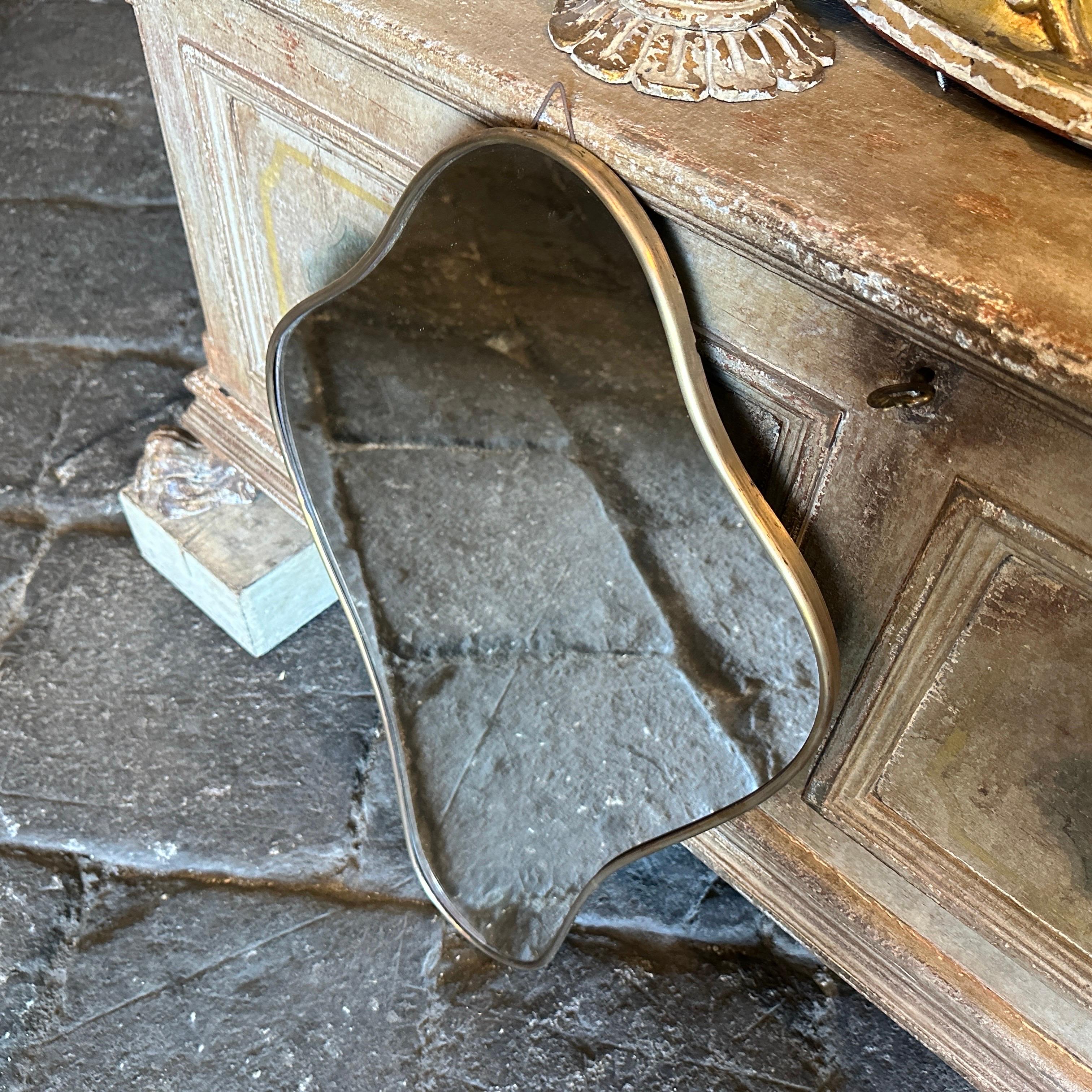 Miroir mural en laiton conçu et fabriqué en Italie par Luigi fortuna dans le style de Gio Ponti. Ce miroir mural en forme de puits est une pièce étonnante et élégante qui capture l'essence du design du milieu du siècle. Inspiré par le célèbre