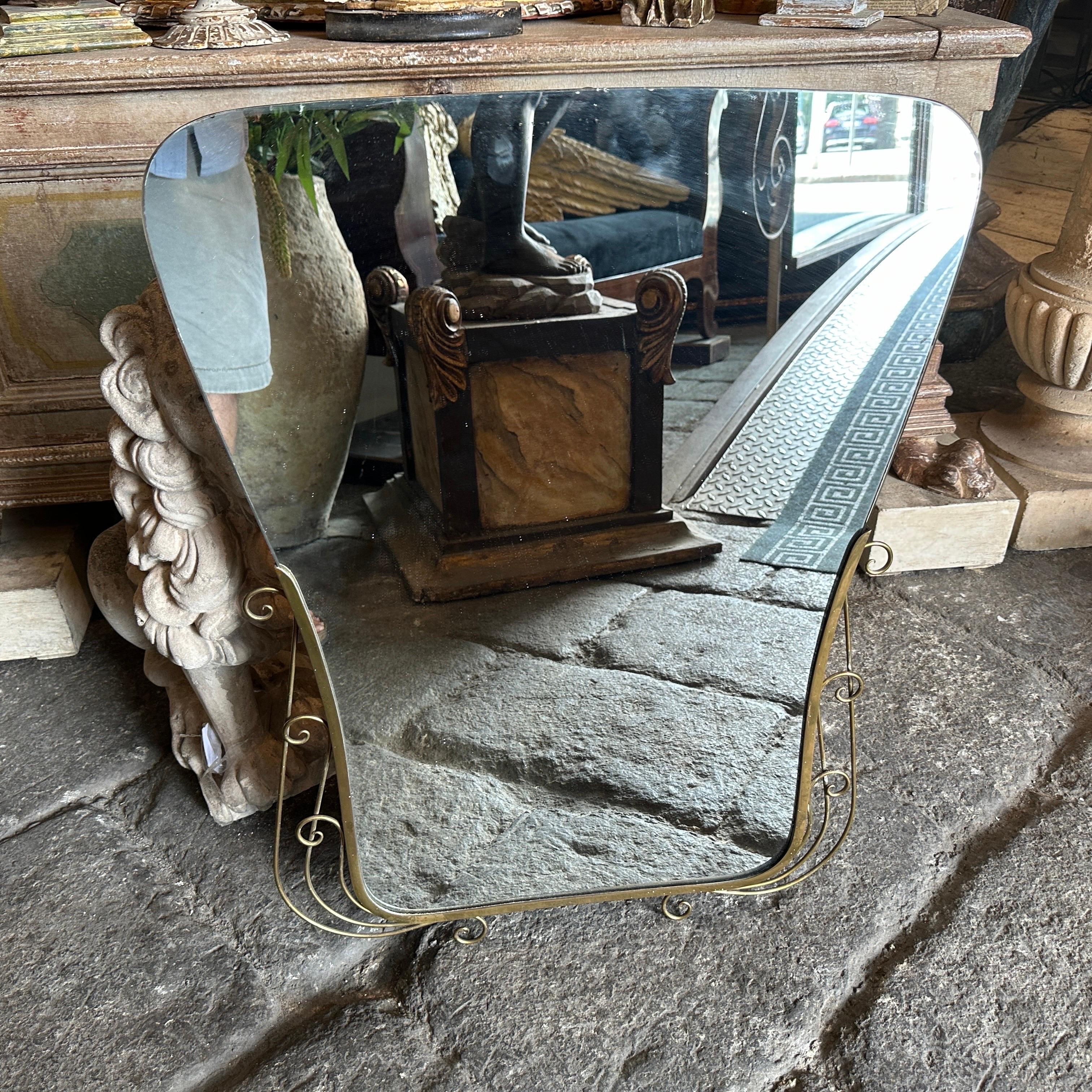 An amazing mid-century modern biscuit shaped solid brass wall mirror hand-crafted in Italy in the Fifties in the manner of Gio Ponti which he used these wall mirrors to furnish the most prestigious homes in Milan in the 1950s. The mirror it's in