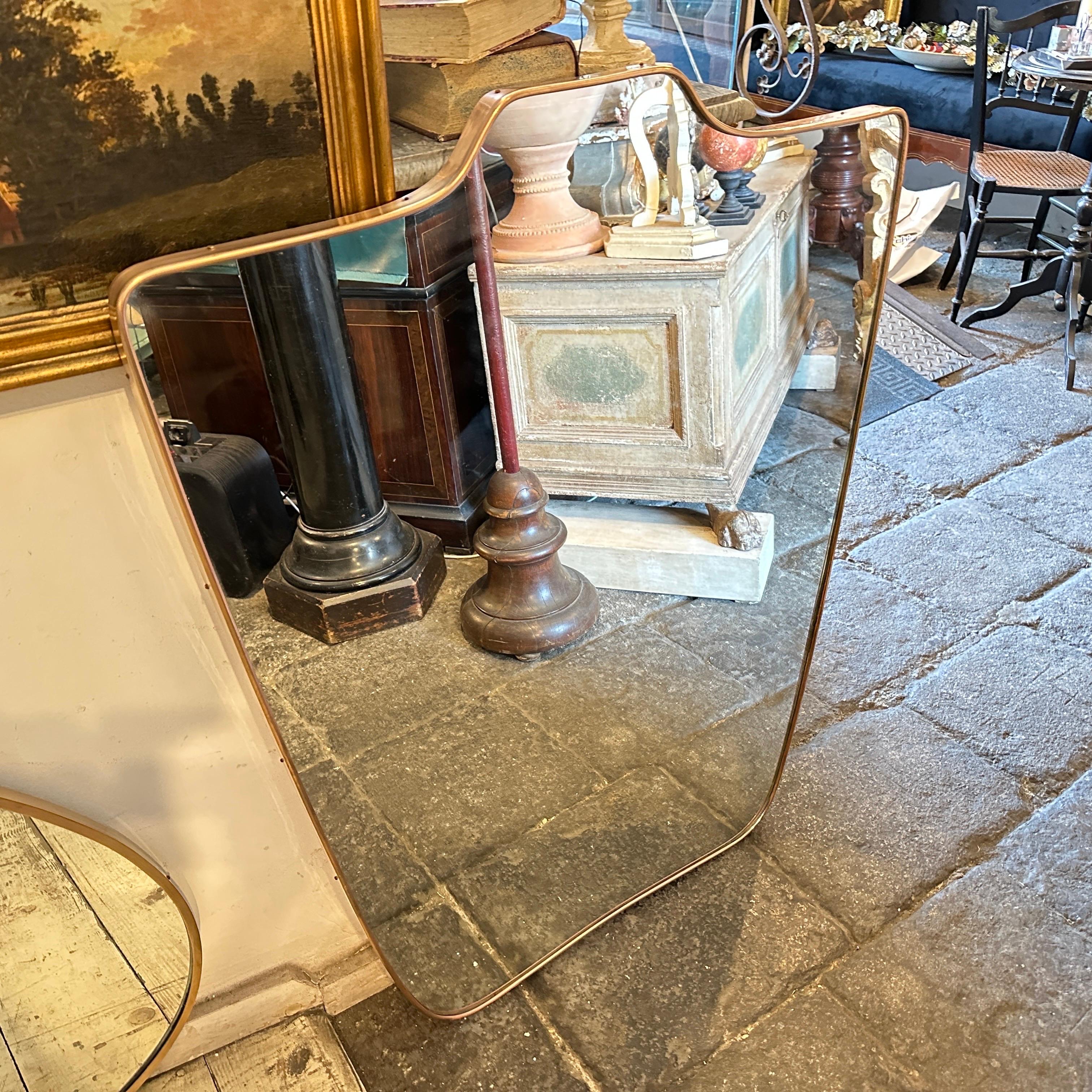 Ein erstaunlicher großer schildförmiger Wandspiegel aus massivem Messing, der in den fünfziger Jahren in Italien in der Art von Gio Ponti handgefertigt wurde, der mit diesen Wandspiegeln die prestigeträchtigsten Häuser in Mailand in den fünfziger