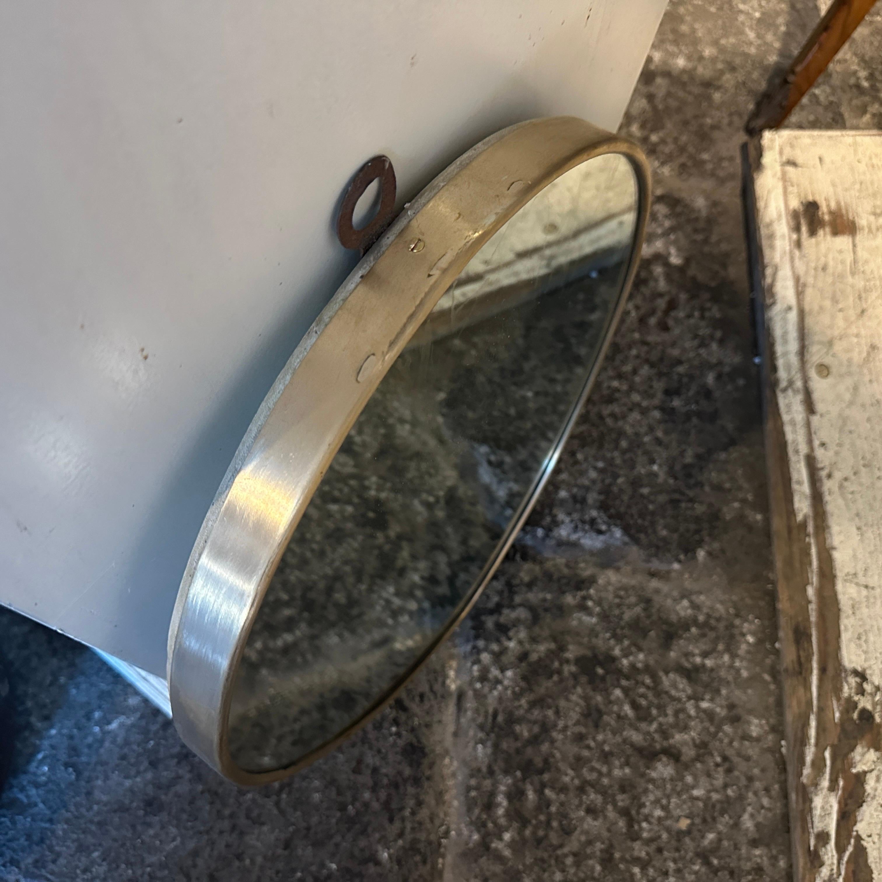 A solid brass wall mirror designed and manufactured in Italy in the Fifties in the manner of Gio Ponti, it's in good conditions overall. The wall mirror is a stunning piece of vintage design that embodies the essence of mid-century aesthetics.