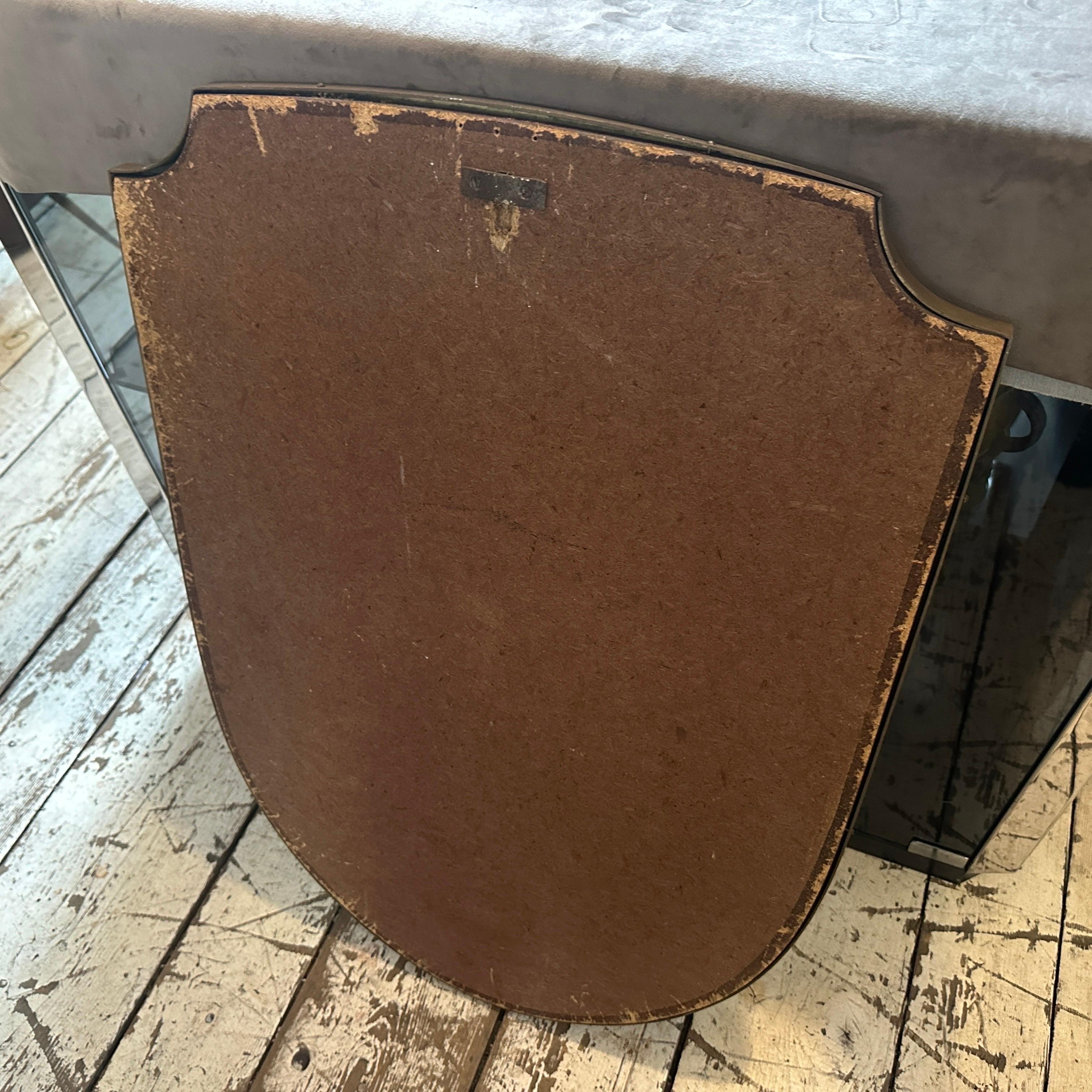 Ein schildförmiger Wandspiegel aus Messing, entworfen und hergestellt in Italien in den sechziger Jahren im Stil von Giò Ponti, in gutem Zustand, Messing mit originaler Patina. Dieser Wandspiegel mit Schild ist ein wunderschönes Stück Vintage-Dekor,