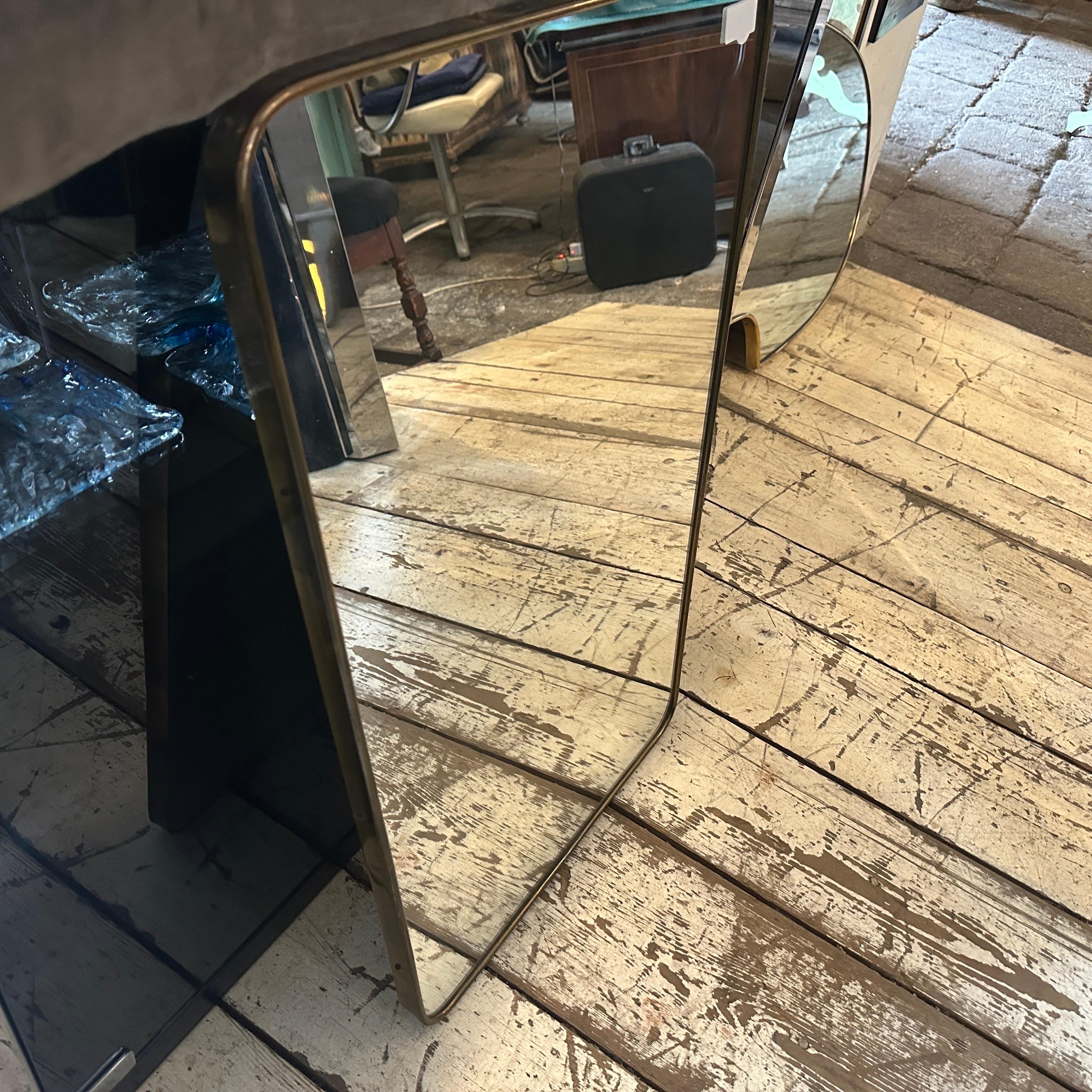 An amazing mid-century modern biscuit shaped wall mirror hand-crafted in Italy in the Fifties in the manner of Gio Ponti which he used these wall mirrors to furnish the most prestigious homes in Milan in the 1950s. The mirror brass frame it's in