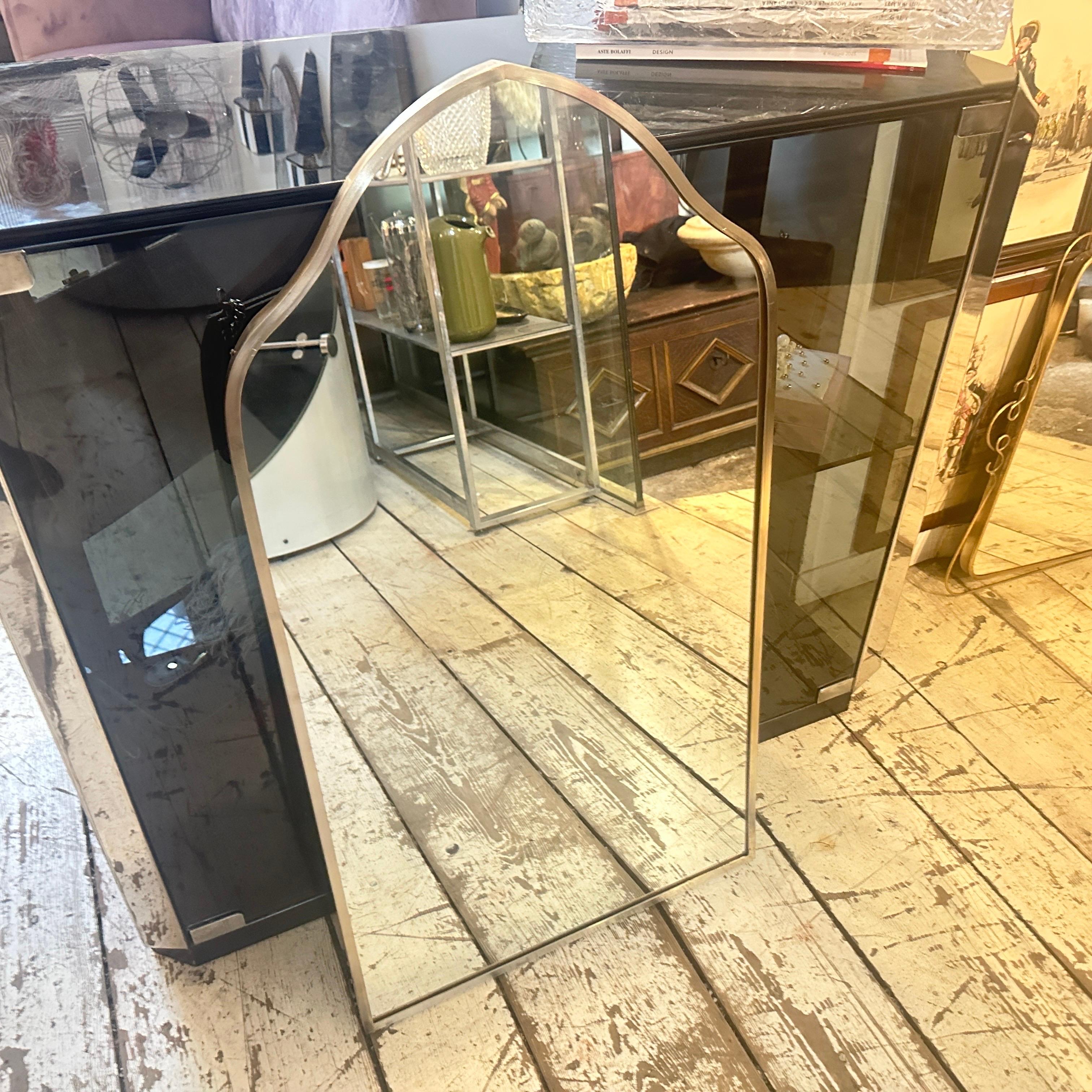 Un espejo de pared de latón macizo diseñado y fabricado en Italia a la manera de Gio Ponti, que utilizó este tipo de espejo en las casas más bellas de Milán en los años 50. El latón presenta una bonita pátina original, mientras que el cristal sigue