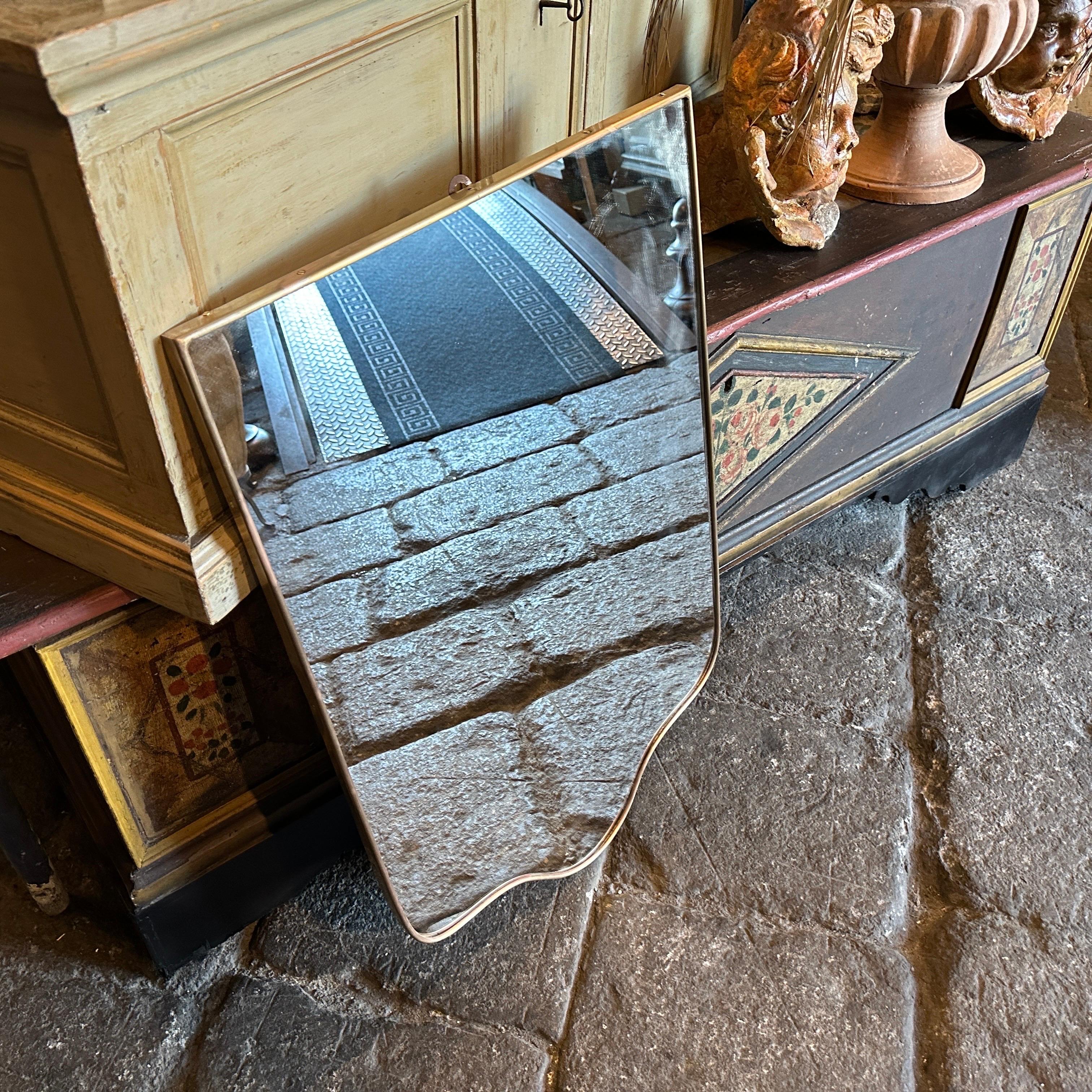 Uno specchio italiano in ottone massiccio del Mid-Century Modern, progettato e prodotto in Italia negli anni Cinquanta nello stile di Gio Ponti, è in ottime condizioni generali. Vanta un design elegante e raffinato con linee pulite e un'estetica