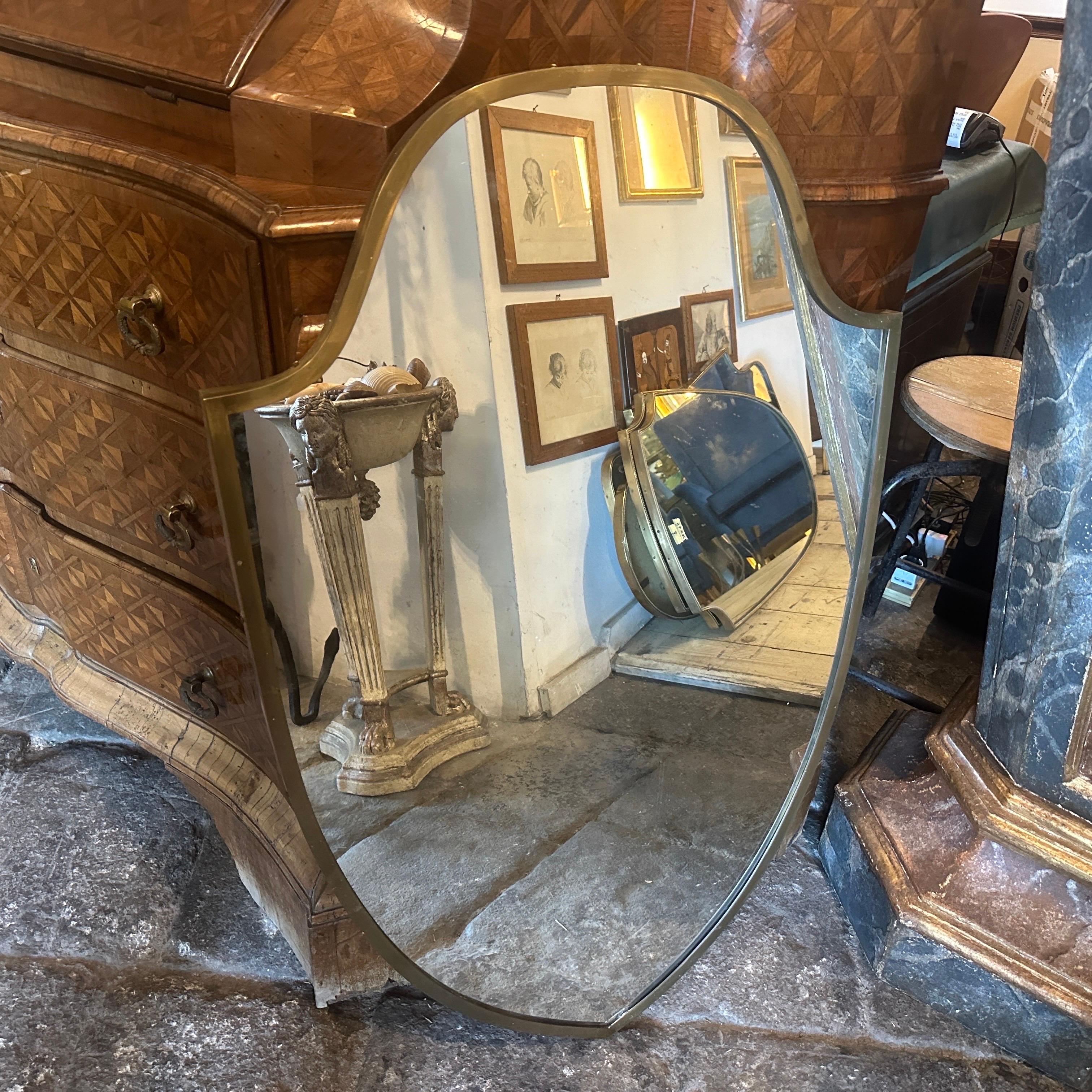 A shield shaped wall mirror designed and manufactured in Italy in the Fifties in the manner of Gio Ponti who used these mirrors to furnish the most beautiful Italian homes of the 1950s. The mirror takes the shape of a shield, an uncommon and
